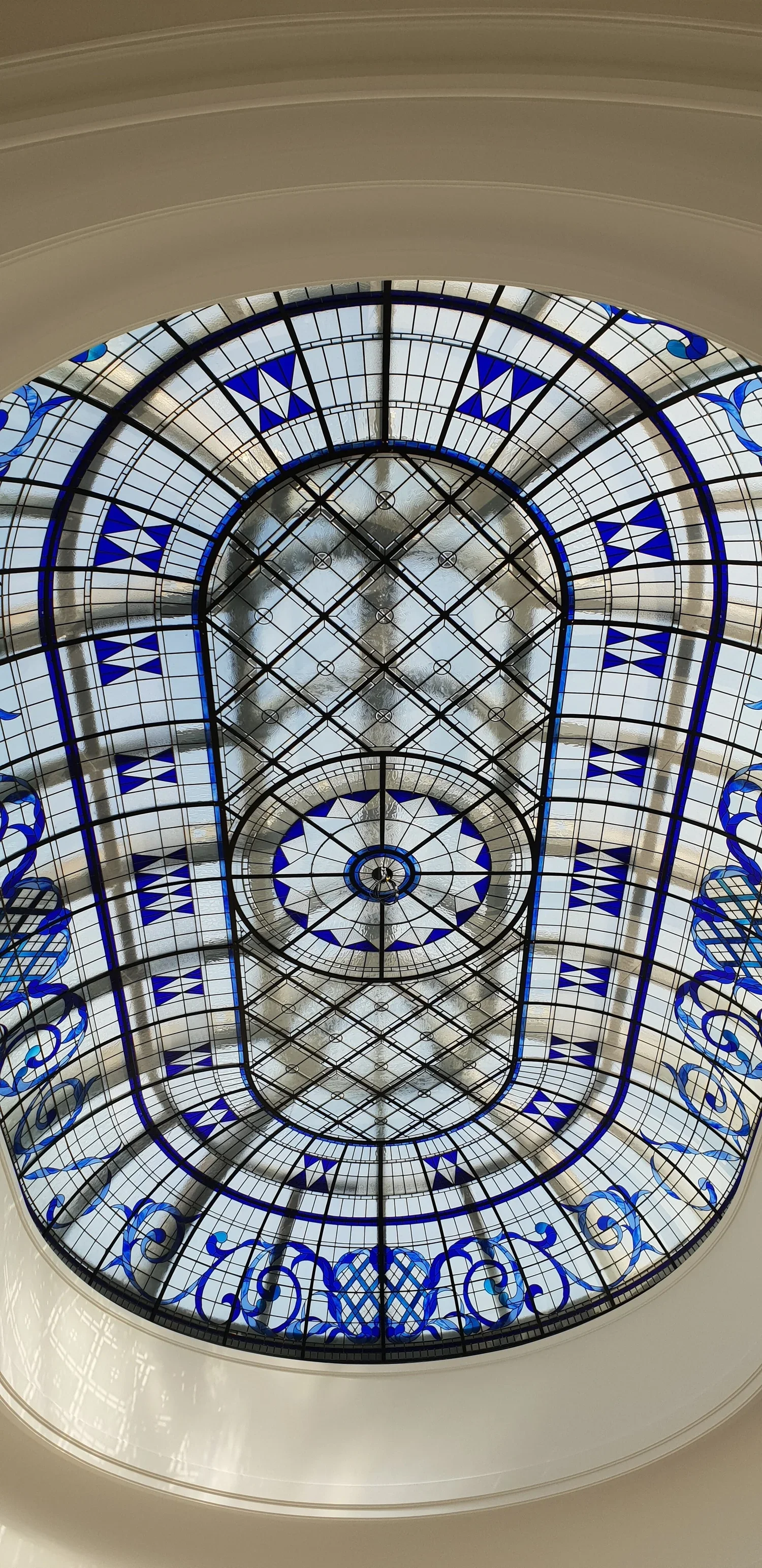 A decorative stained glass ceiling with intricate patterns and blue accents.