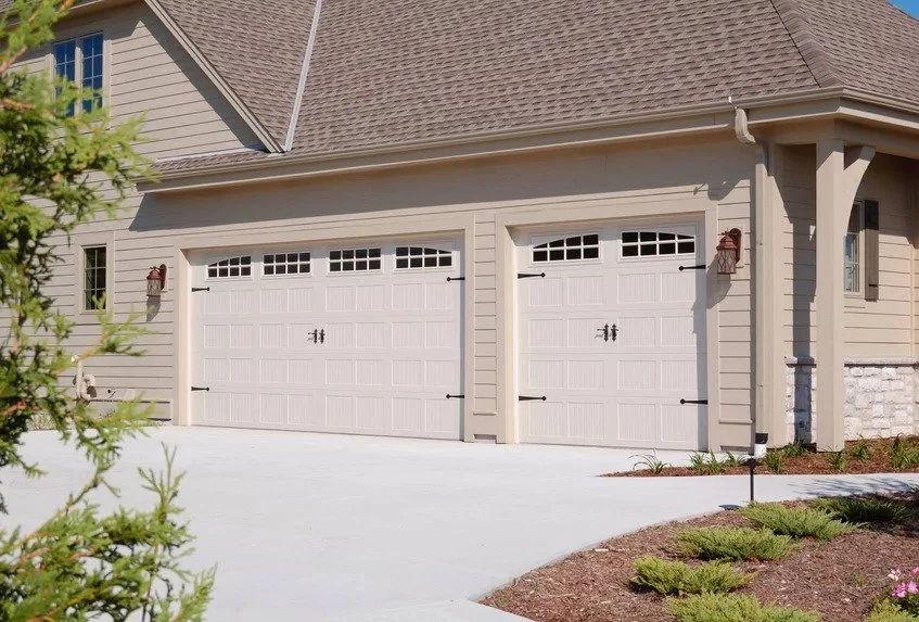 Two Stamped Carriage House Garage Doors on Brown Paneled House