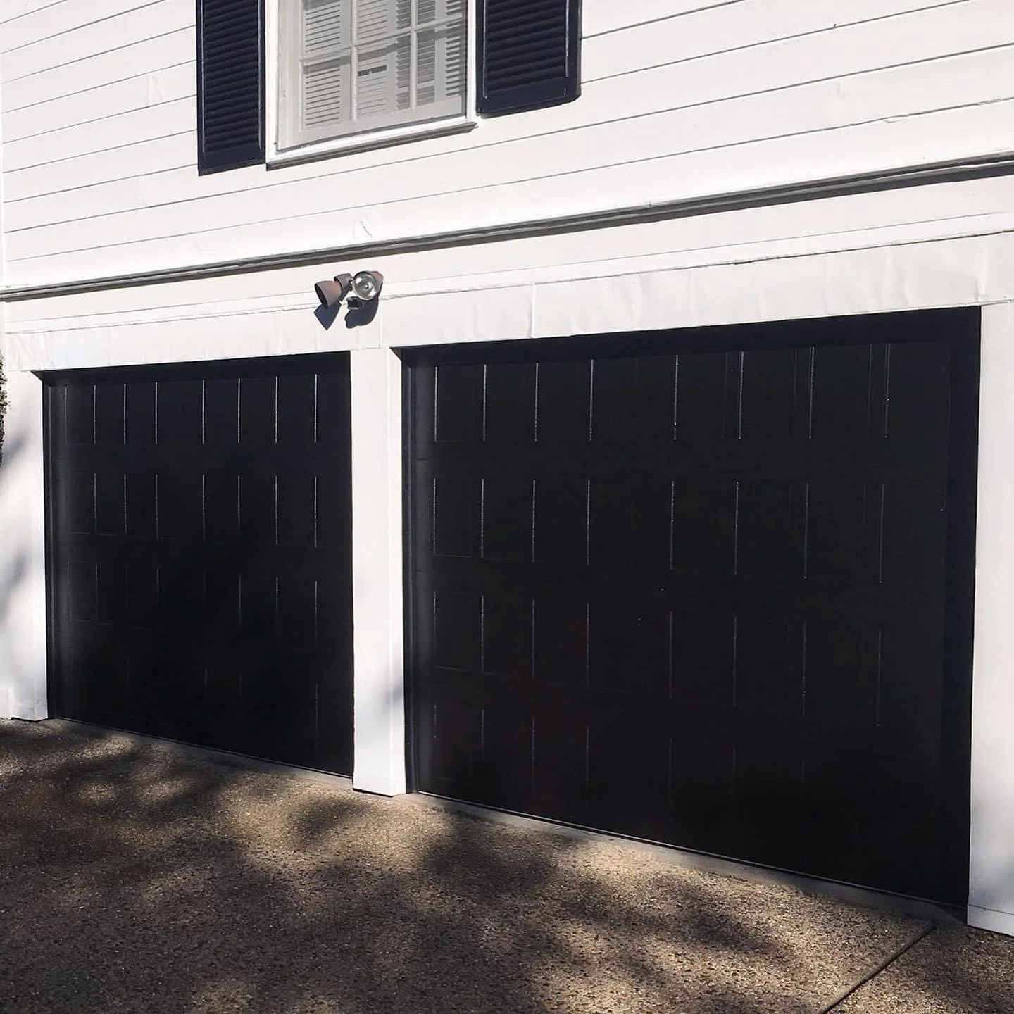 Two Black Stamped Shaker Garage Doors on White House