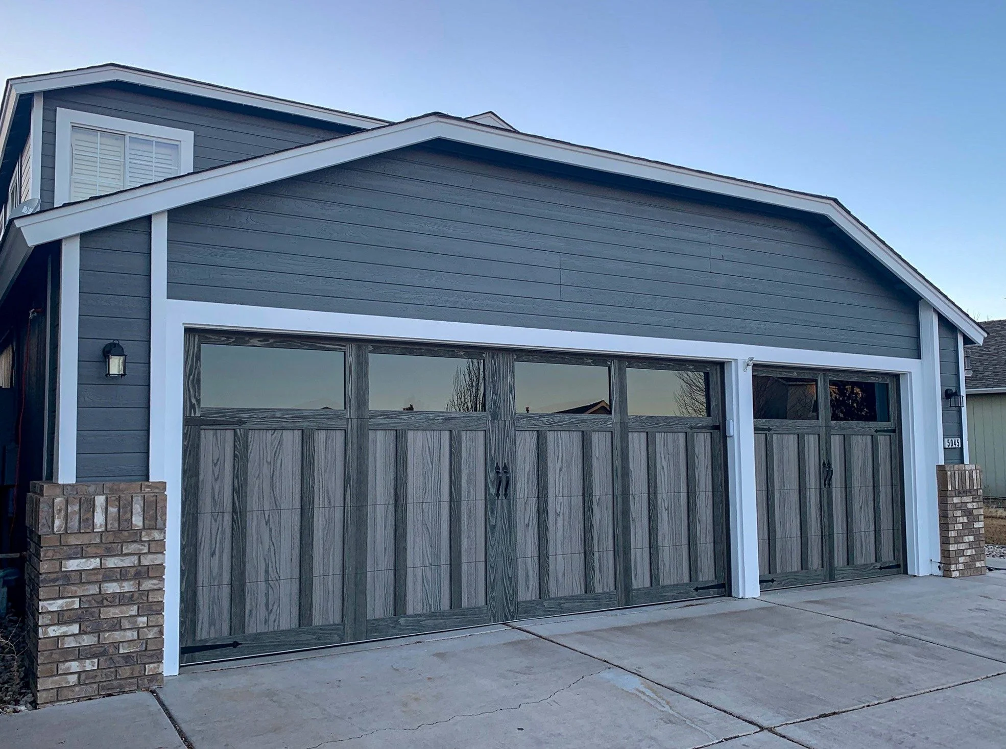 Two Dark Gray Wooden Carriage Collection Garage Doors on Gray House
