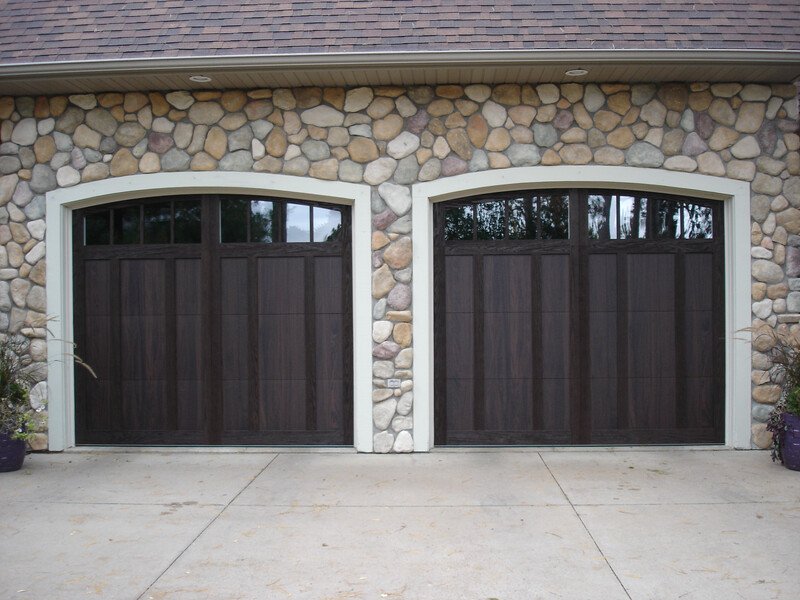 Two Dark Wooden Carriage Collection Garage Doors on Stone House