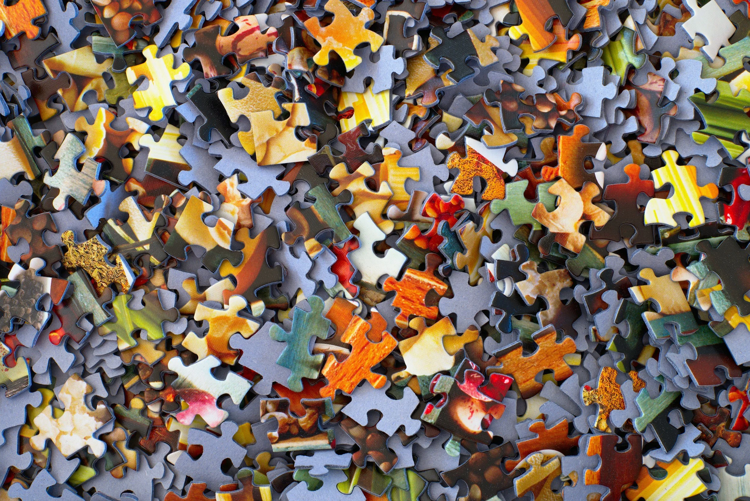 A pile of assorted, colorful jigsaw puzzle pieces