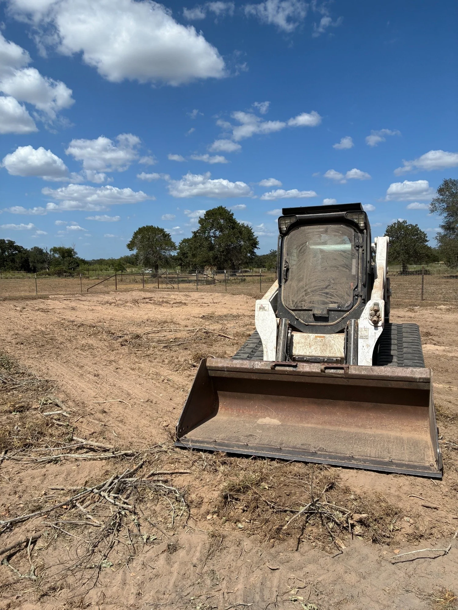 Woodchuck Bobcat with bucket on a cleared Central Texas property