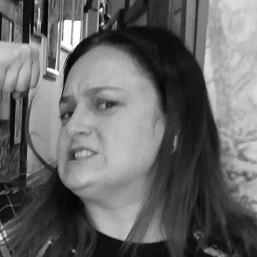 Silhouette of a person with backlit hair and ears, facing forward, with a dark background.