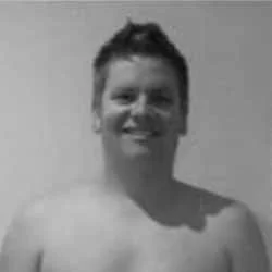 Silhouette of a person with backlit hair and facing forward, sharply contrasted against a dark background.