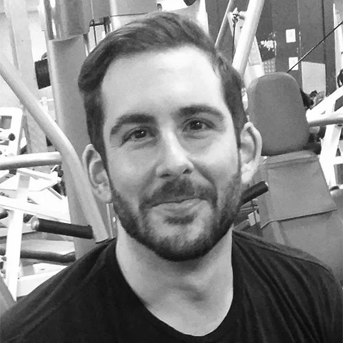 Silhouette of a person with backlit hair, facing forward against a black background.