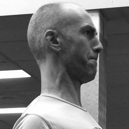 Silhouette of a person's head and shoulders with backlighting on a black background.