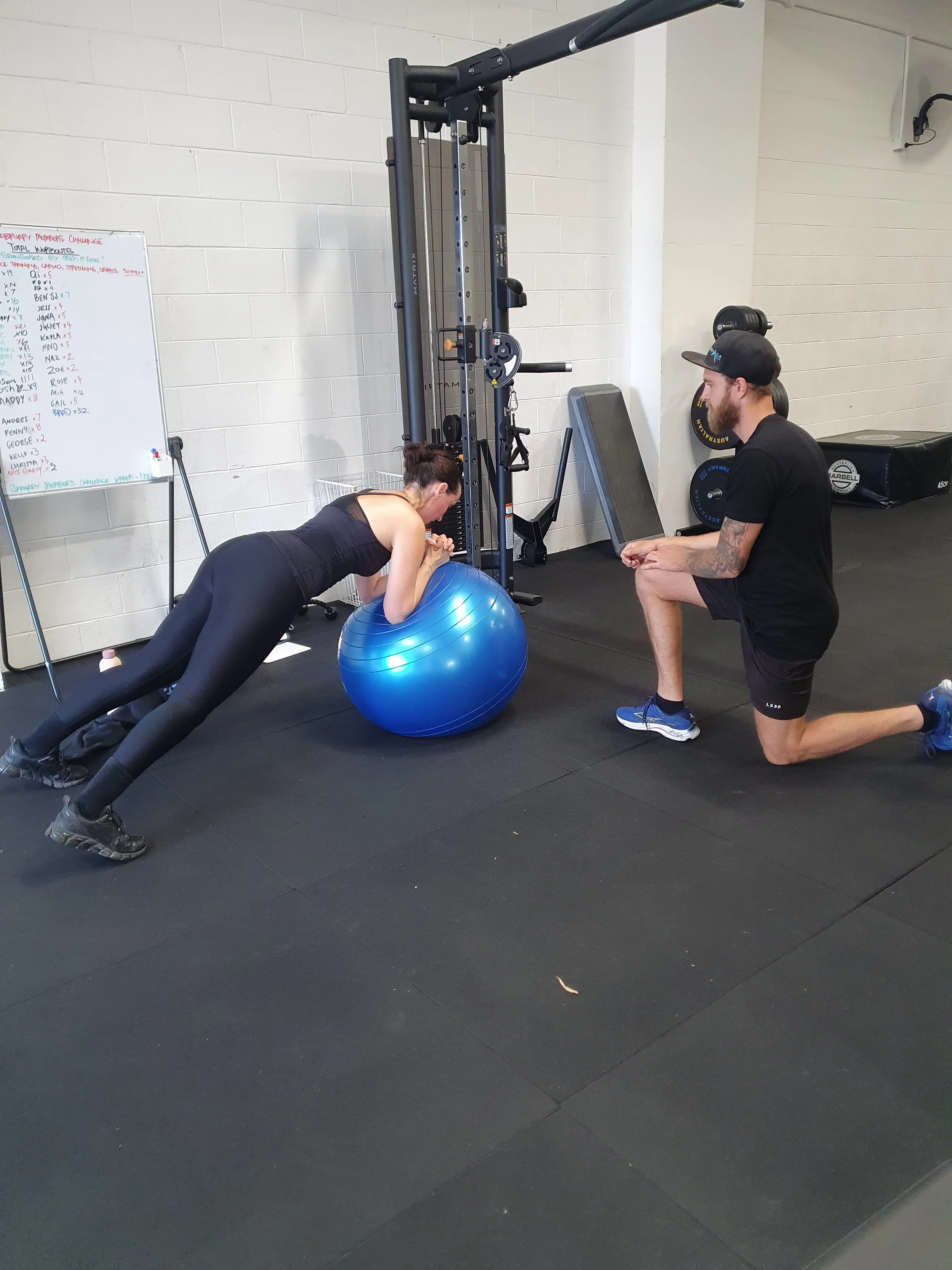 Beyond Best personal trainer coaching a client during a stability and strength exercise in the Collingwood gym.