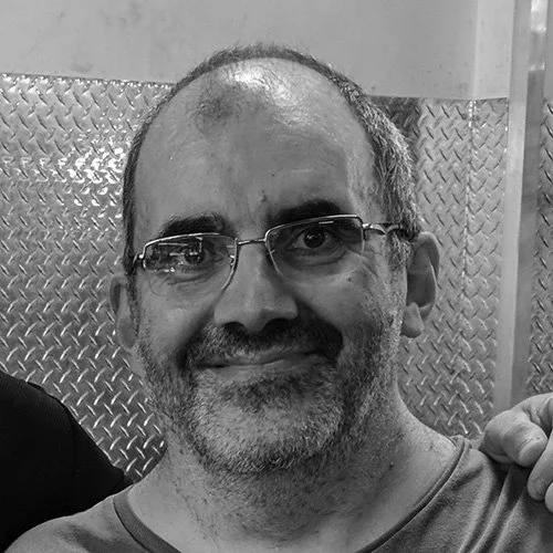 Silhouette of a person with backlit hair and shoulders, silhouette against a dark background.