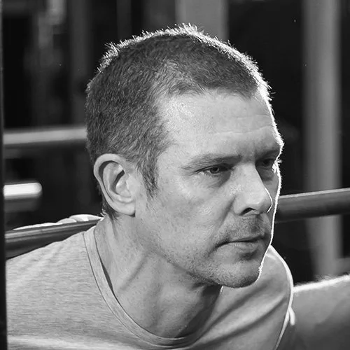 Silhouette of a person with backlit hair and ears against a black background.