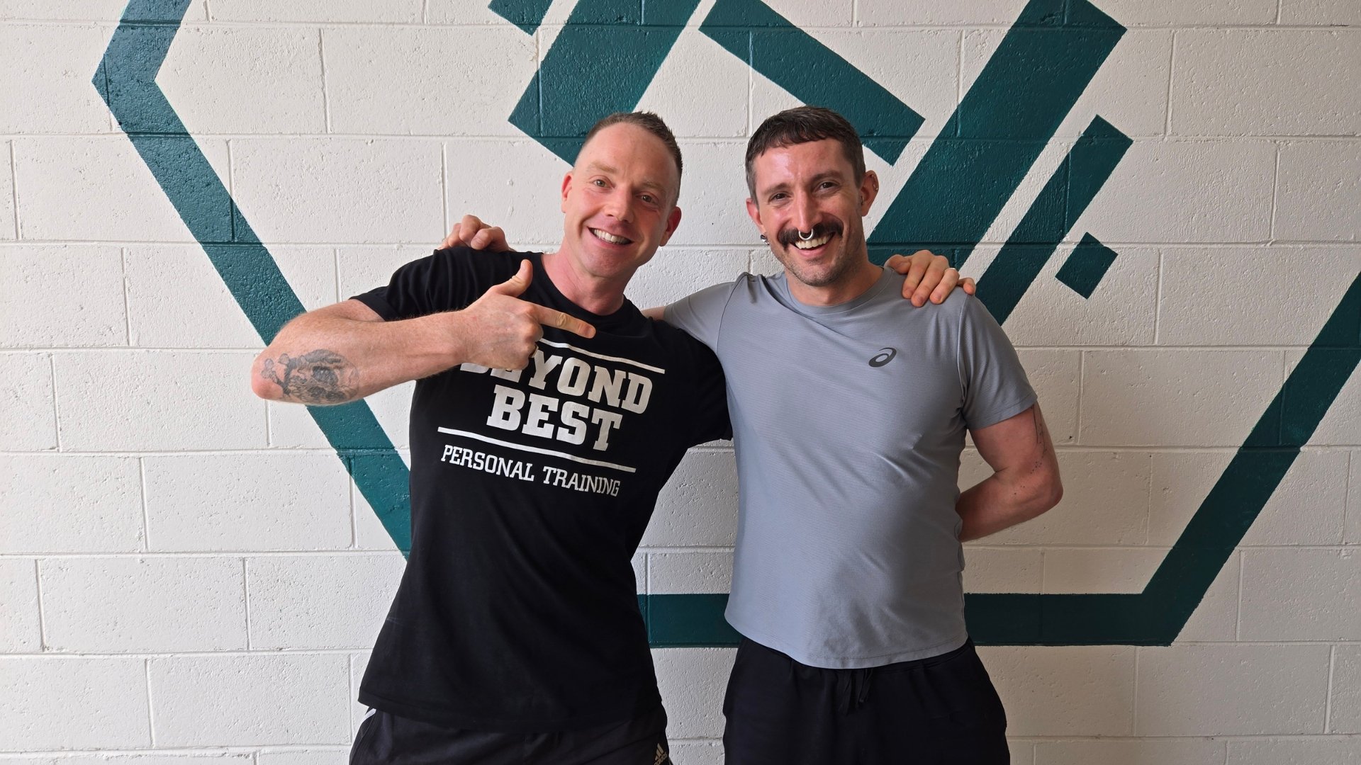 Beyond Best coach standing with a smiling client inside the Collingwood personal training studio.