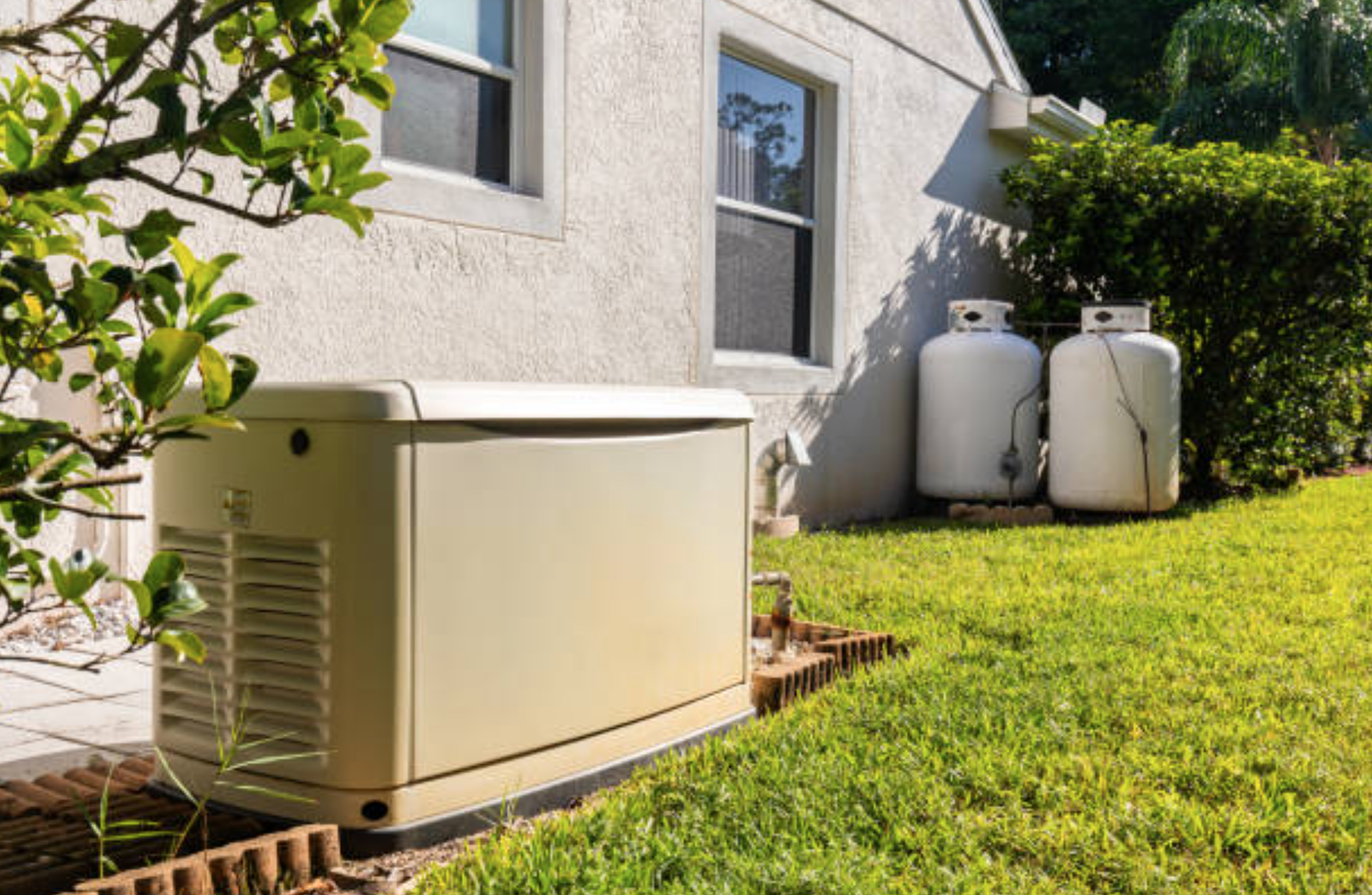 Backyard with air conditioning unit and two propane tanks near a white house with two windows, green grass, and shrubbery.