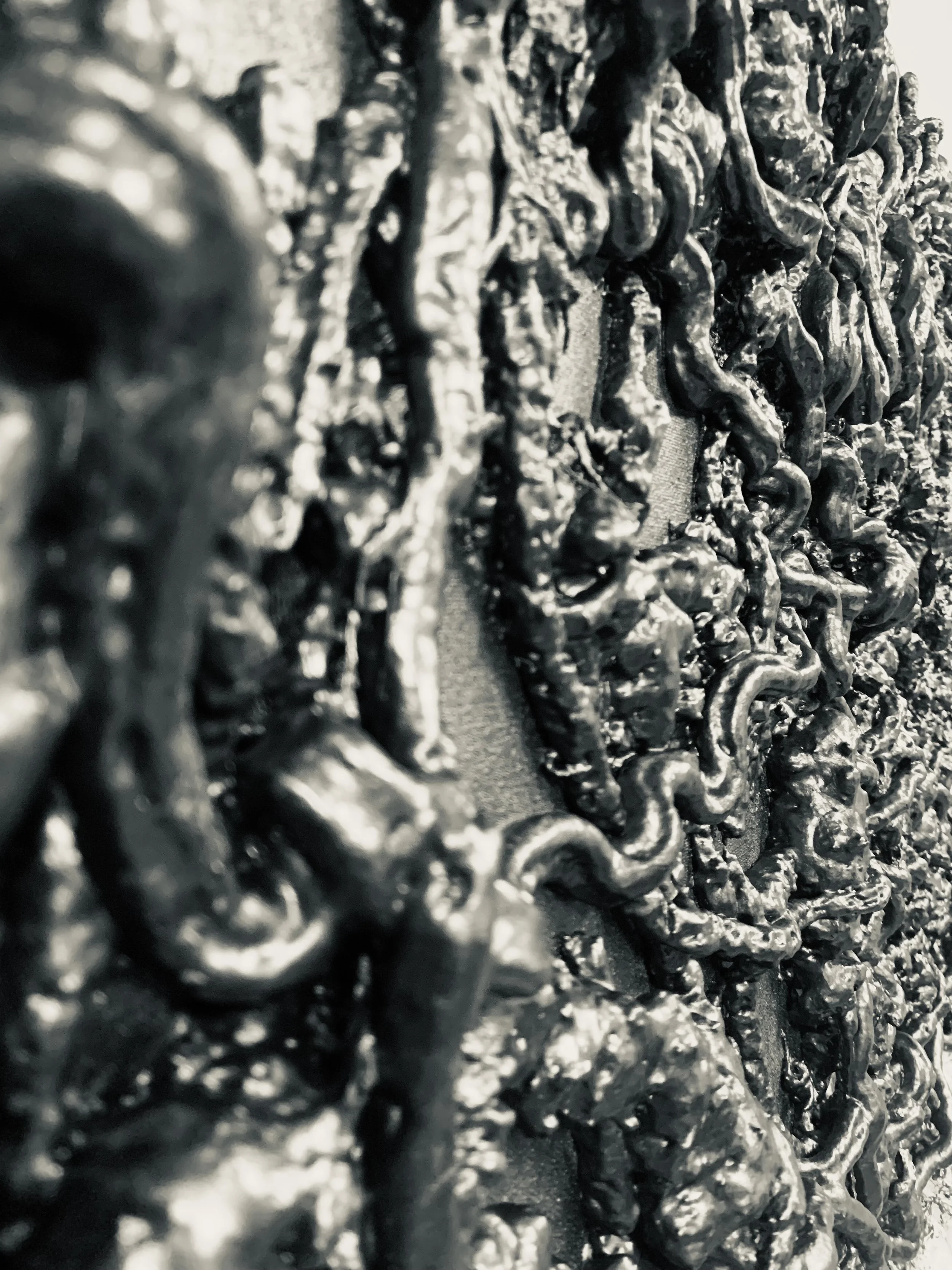 Close-up of shiny, textured, black substance with a rough, uneven surface.