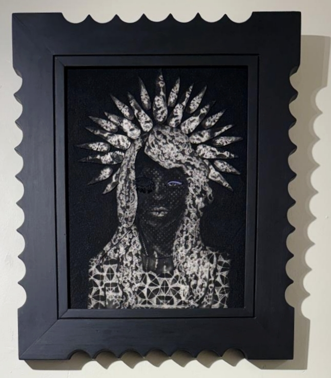 Black framed artwork of a woman with long braided hair and decorative headdress, created with perforated and lace-like details.