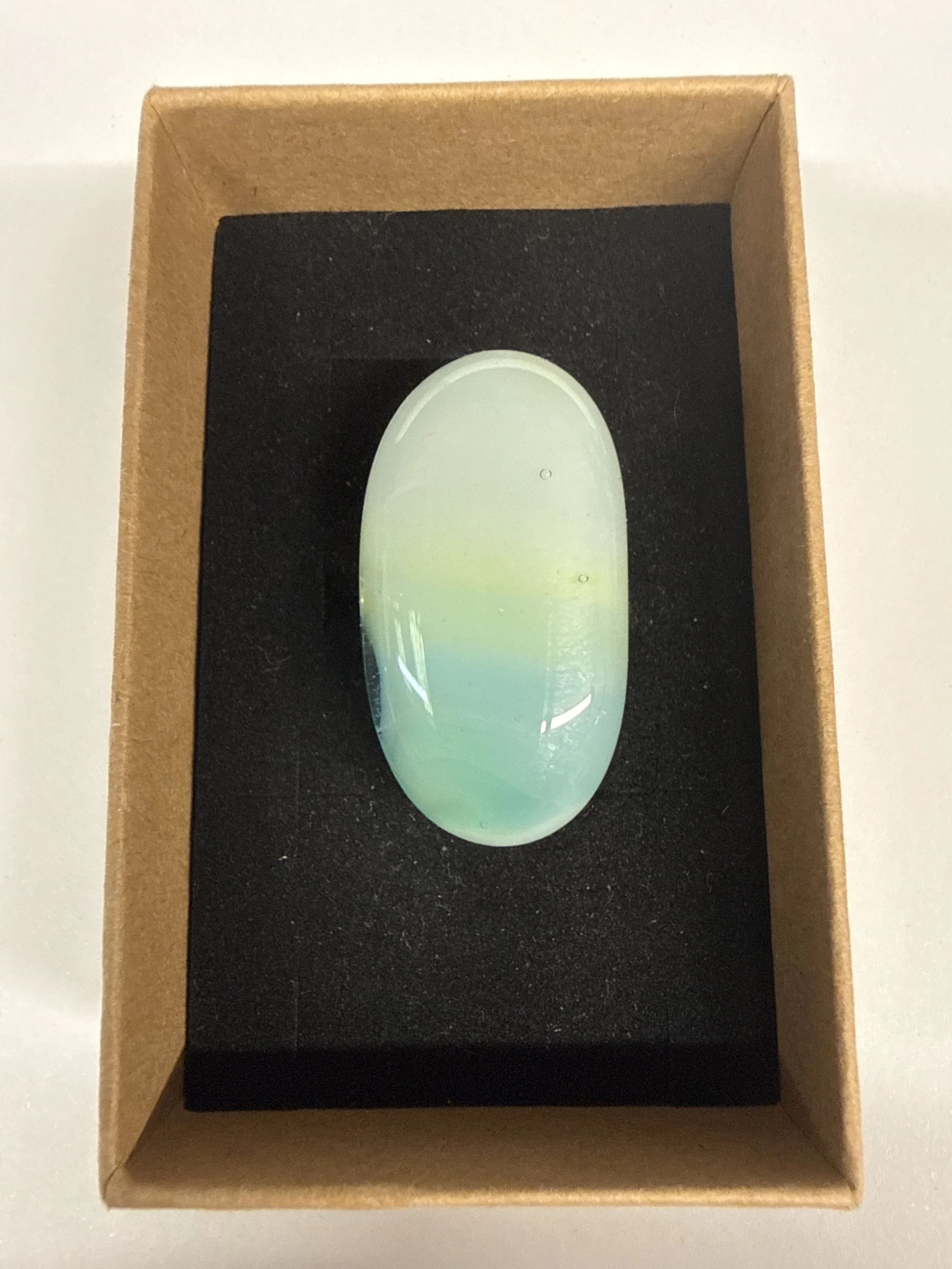 Oval shape ring white green yellow hue