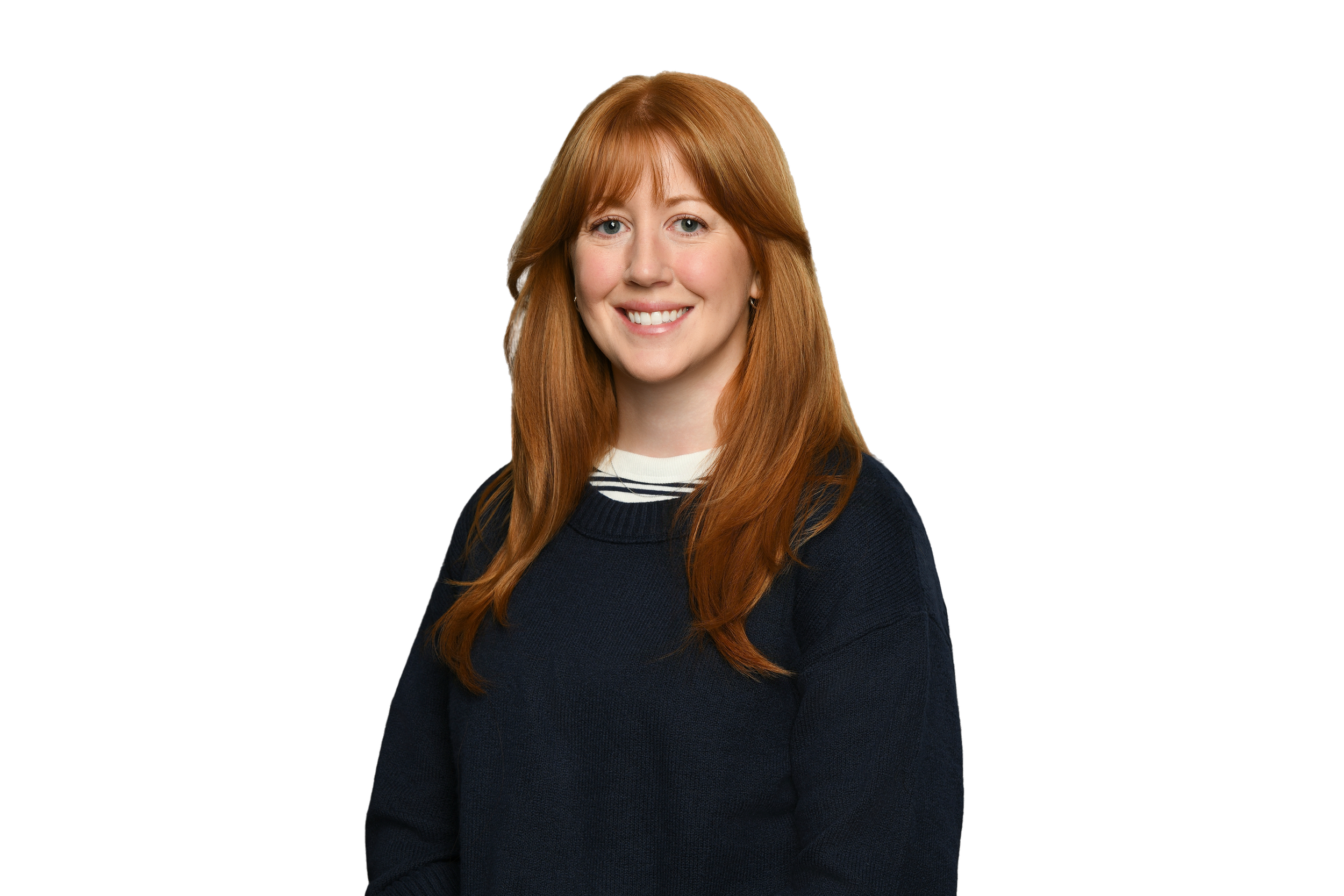 Portrait of a woman with long red hair, wearing a black sweater with a white striped collar, smiling, against a black background.