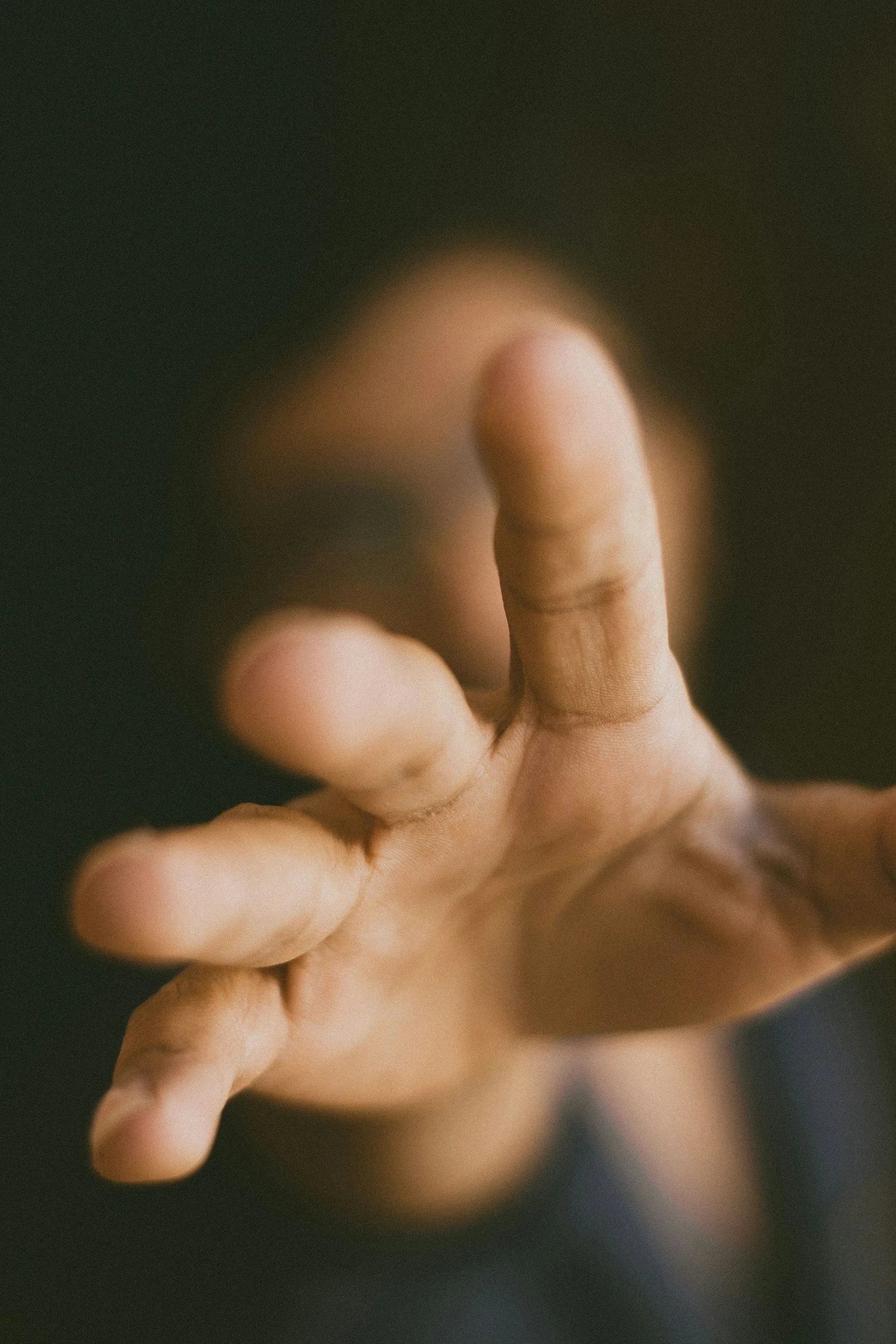Reaching hand emerging from darkness representing virtual pastoral support for men navigating unwanted sexual behavior.