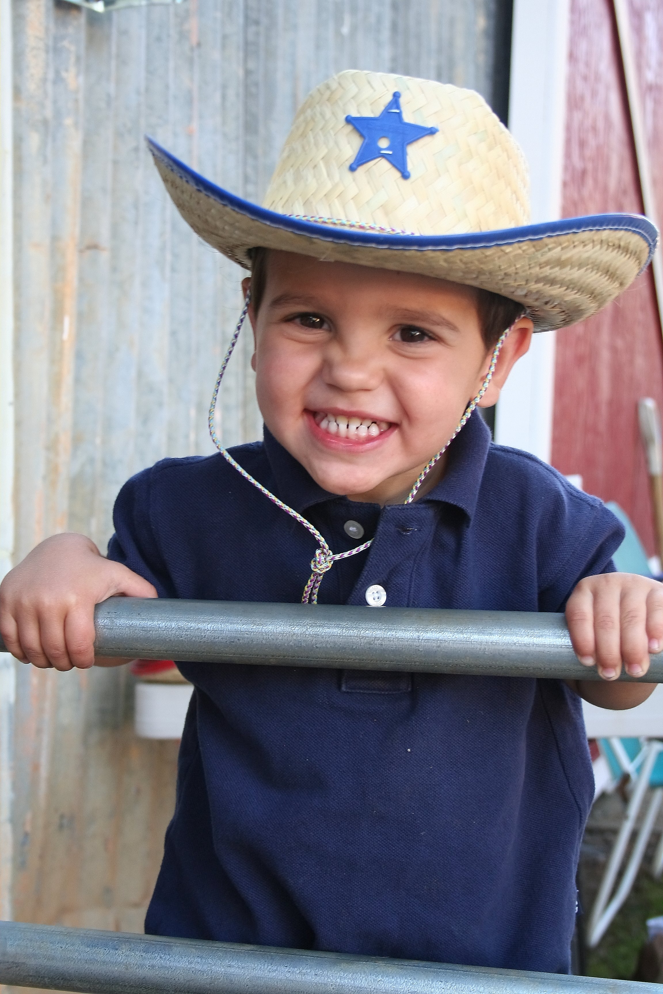 Boy in cowboy hat with big grin
