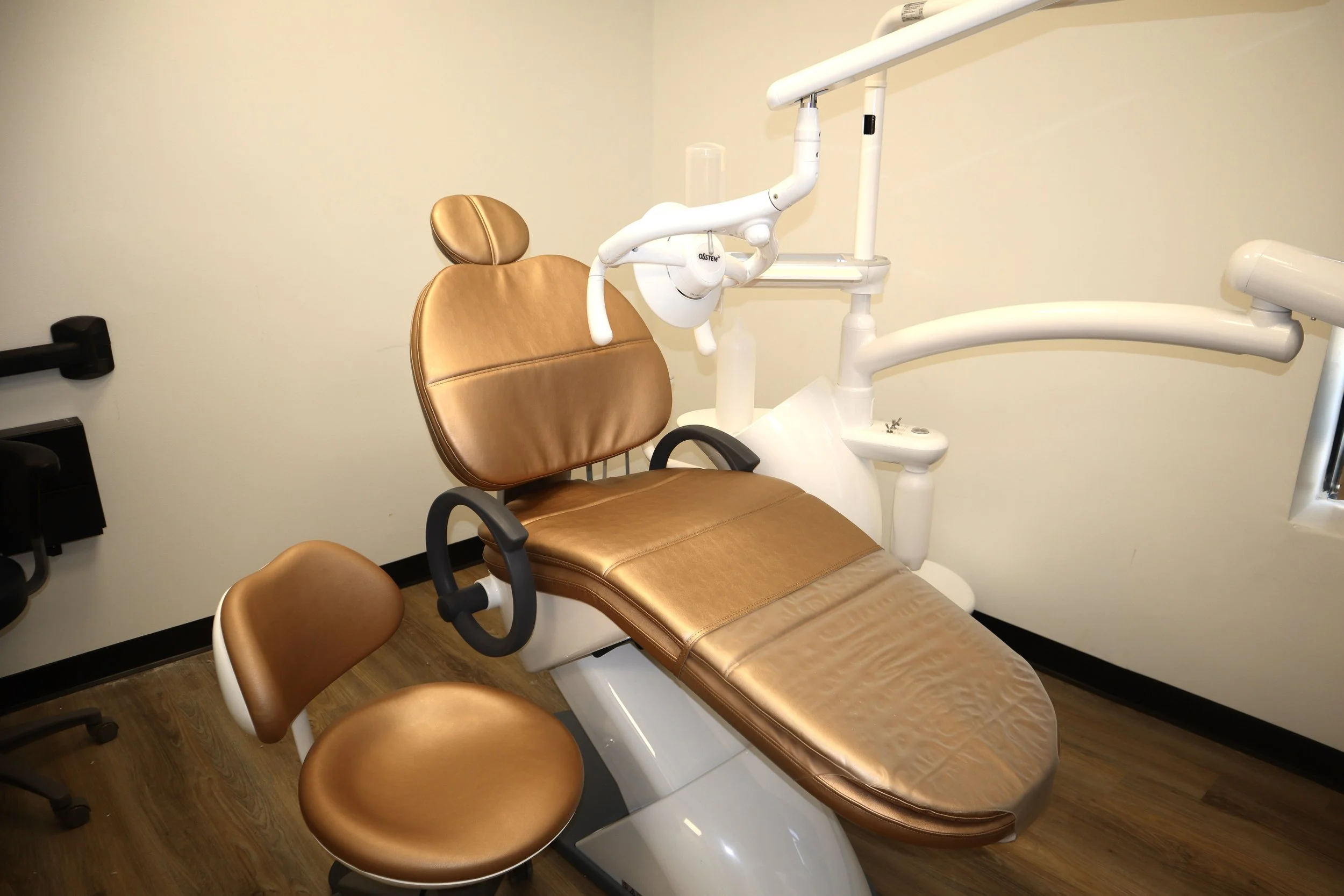 A dental examination chair with brown upholstery in a clinical room.
