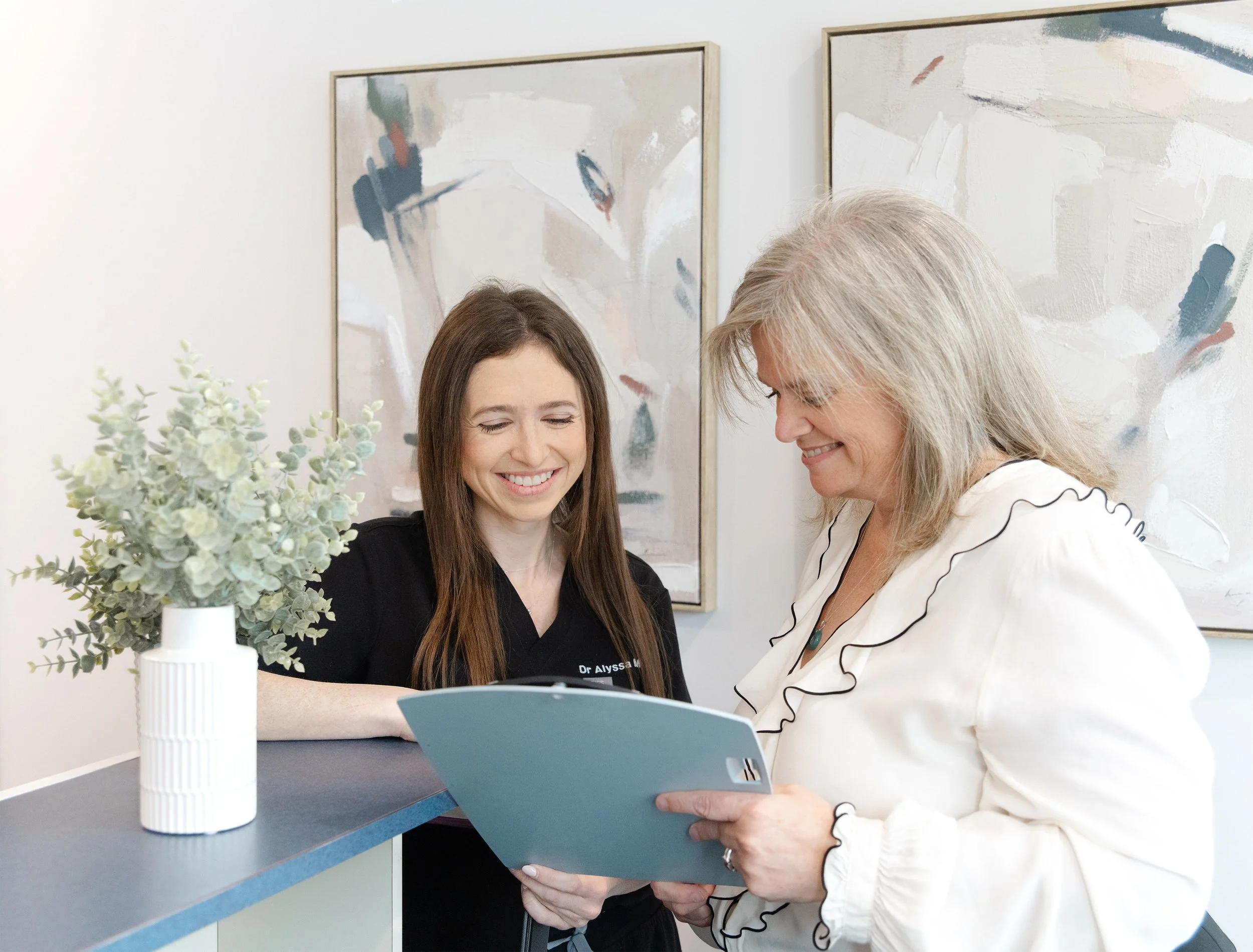 Dentist and office manager coordinating at the front desk of a modern dental clinic