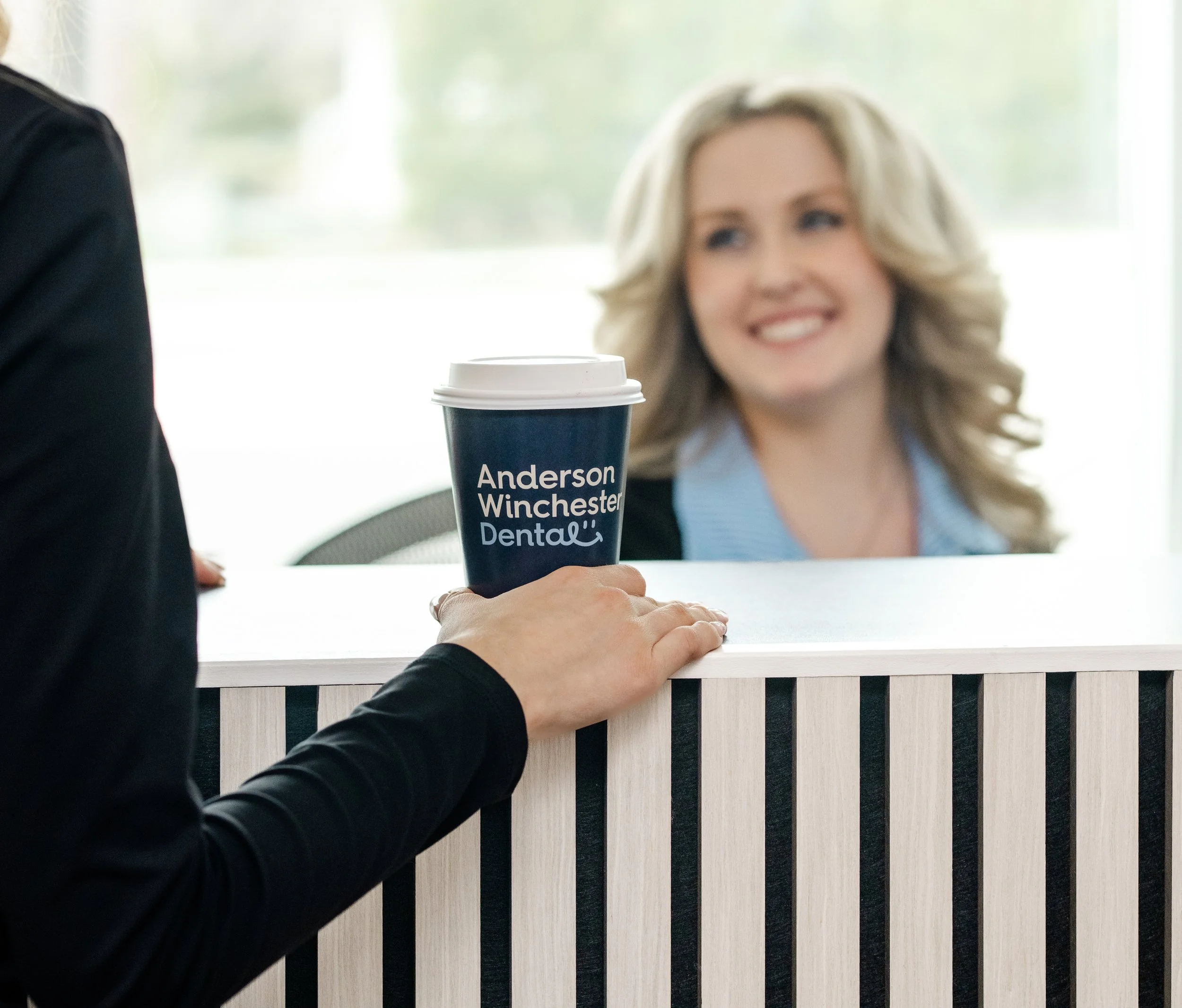 Patient booking an appointment at the reception desk of a modern dental clinic