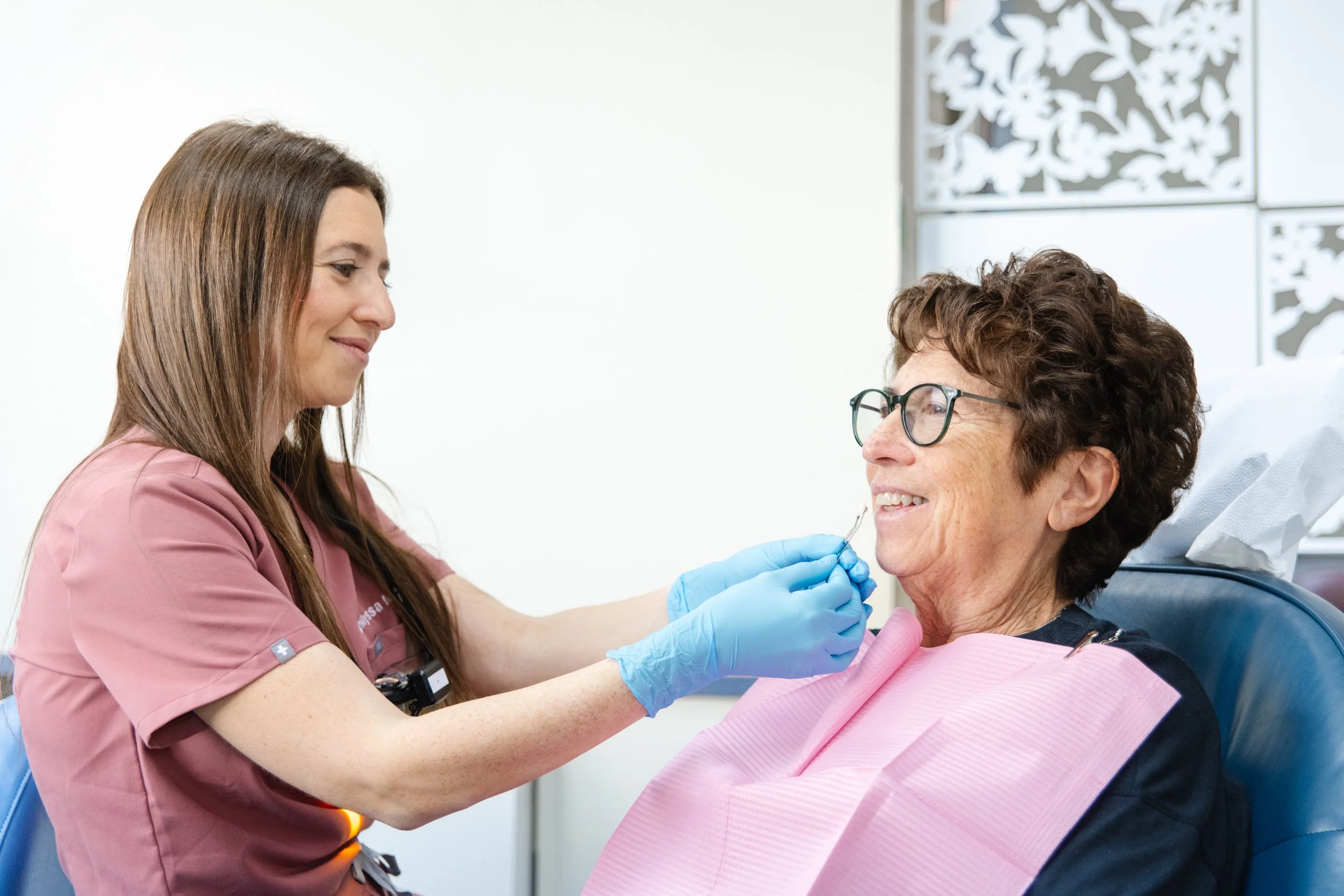A healthcare worker giving a vaccination to an elderly woman in a medical setting.