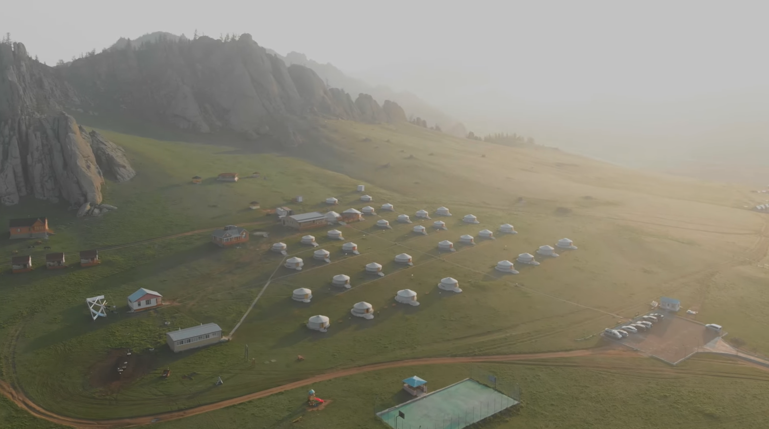 Cinematic drone shot revealing mountain valley landscape and campsite