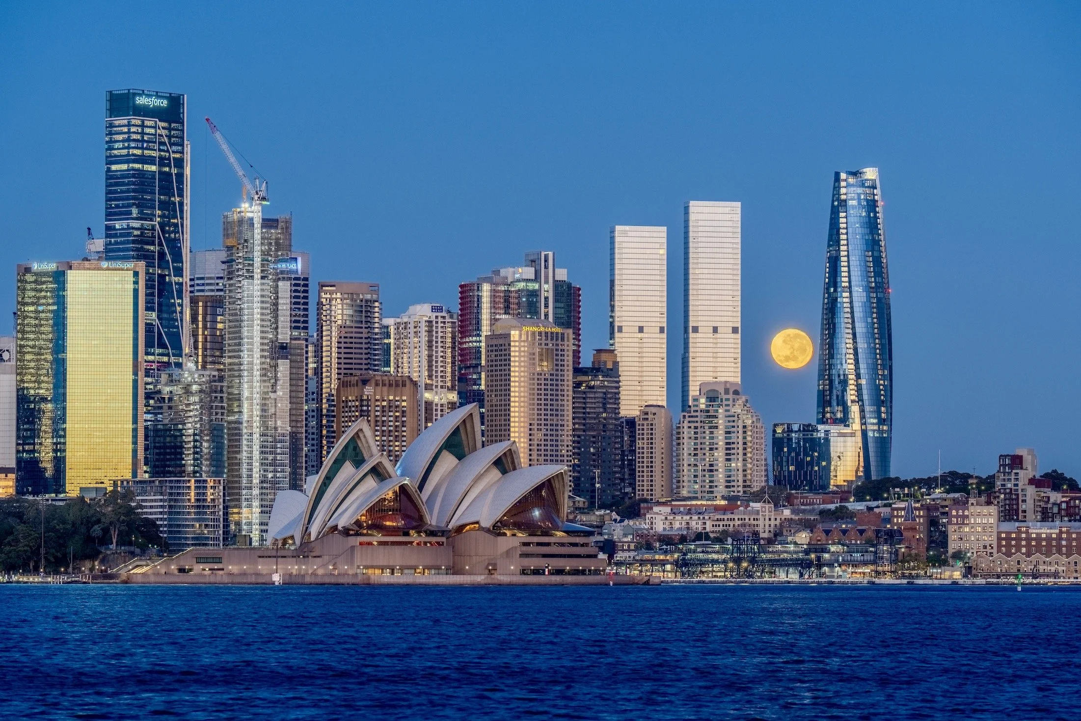 Sydney skyline and Opera House with full moon rising behind the city