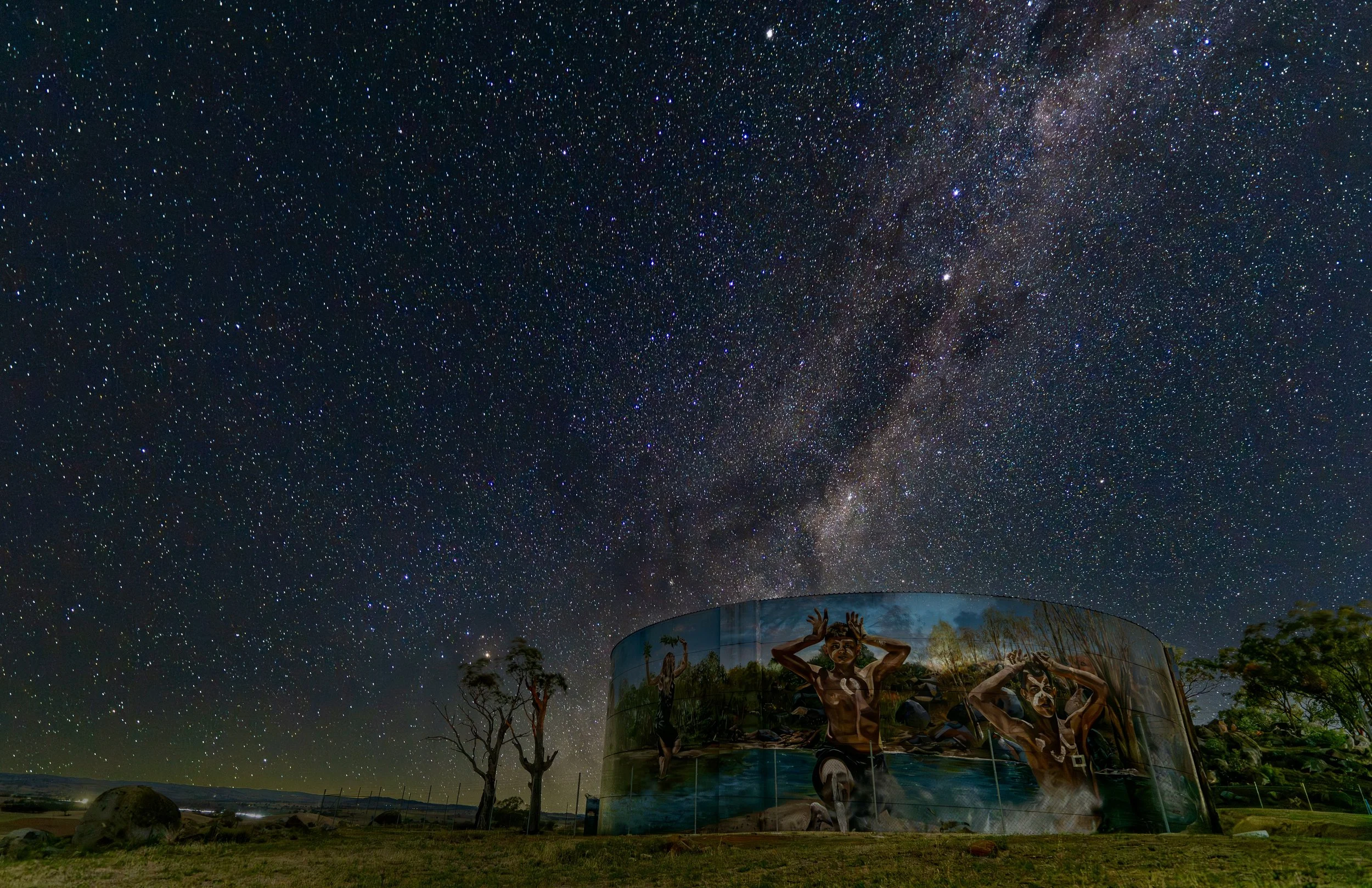 Milky Way night sky over painted water tank in rural Australia