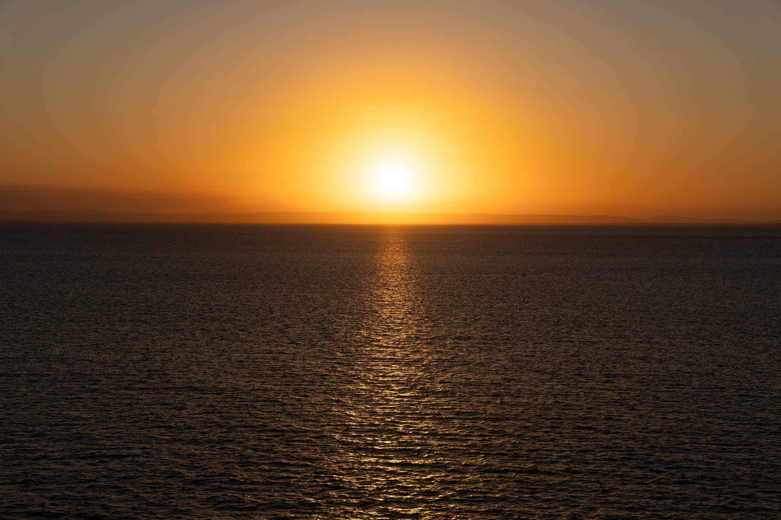 Cinematic aerial view of sunset over the ocean filmed with drone