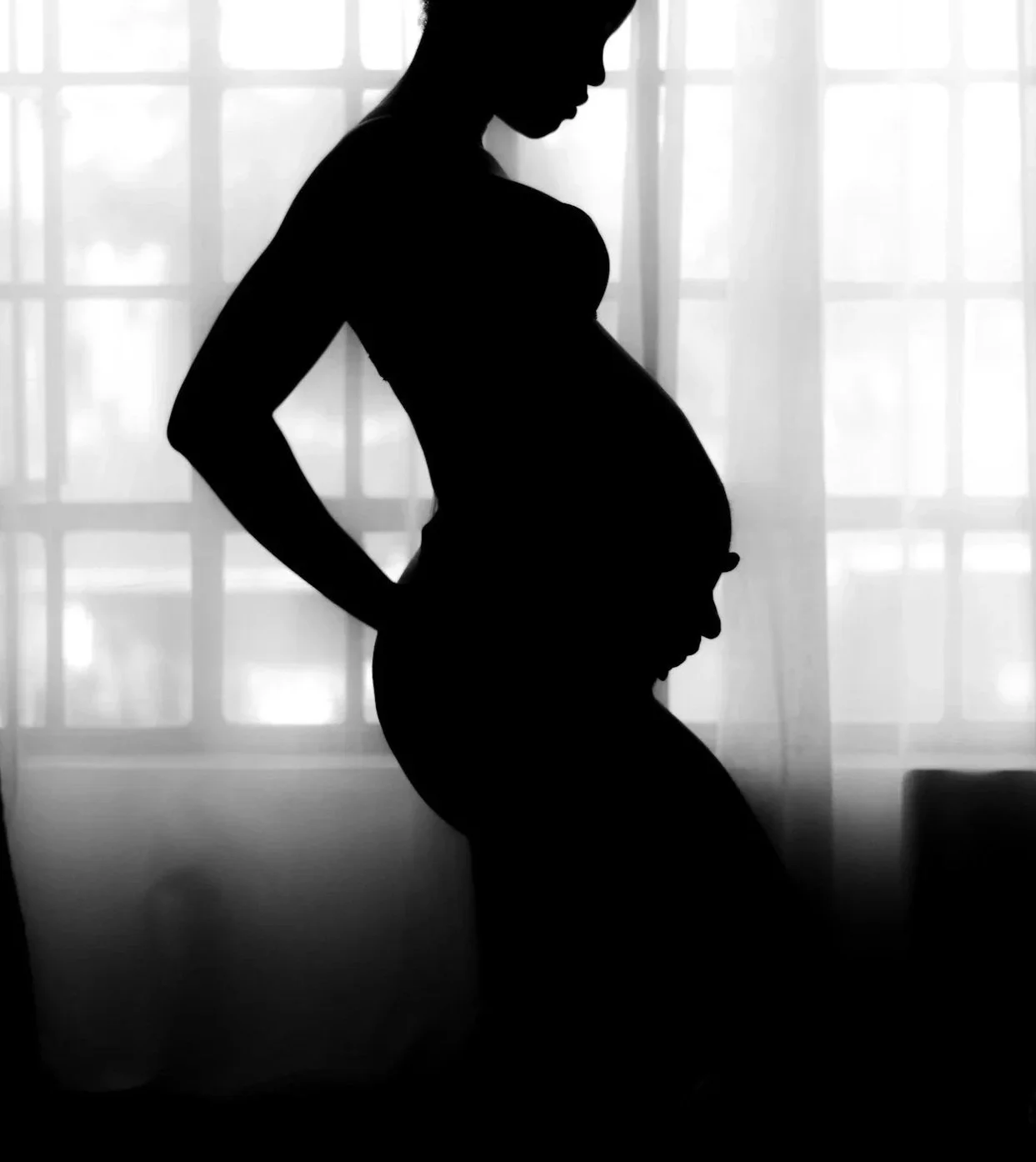 Silhouette of a pregnant woman standing in front of a window with sheer curtains, with her hand resting on her lower back.

Serened Birthing Houston Doula Services available for Houston area pregnant people
