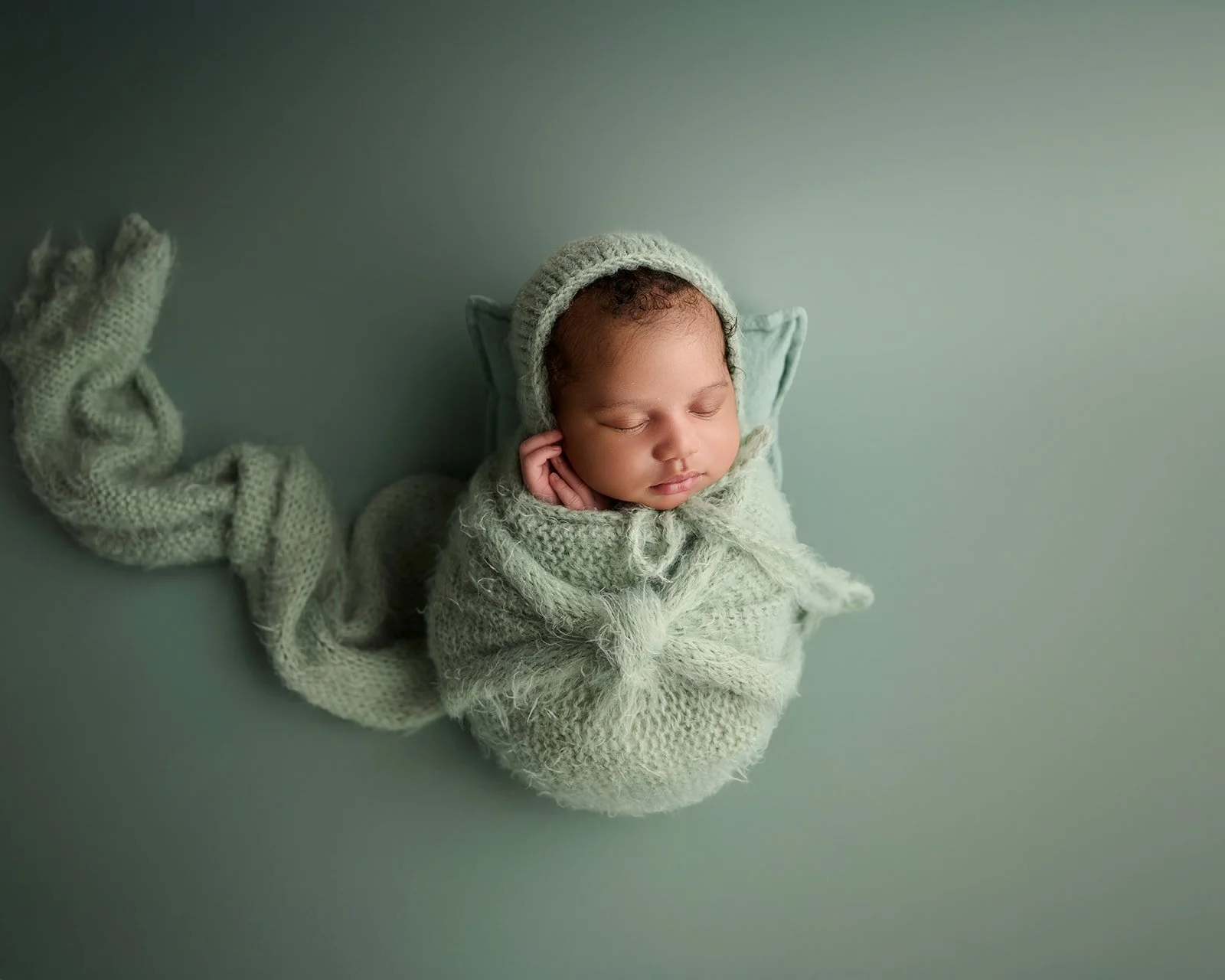 Wrapped newborn baby photographed in a fine art studio newborn session in Cypress Texas