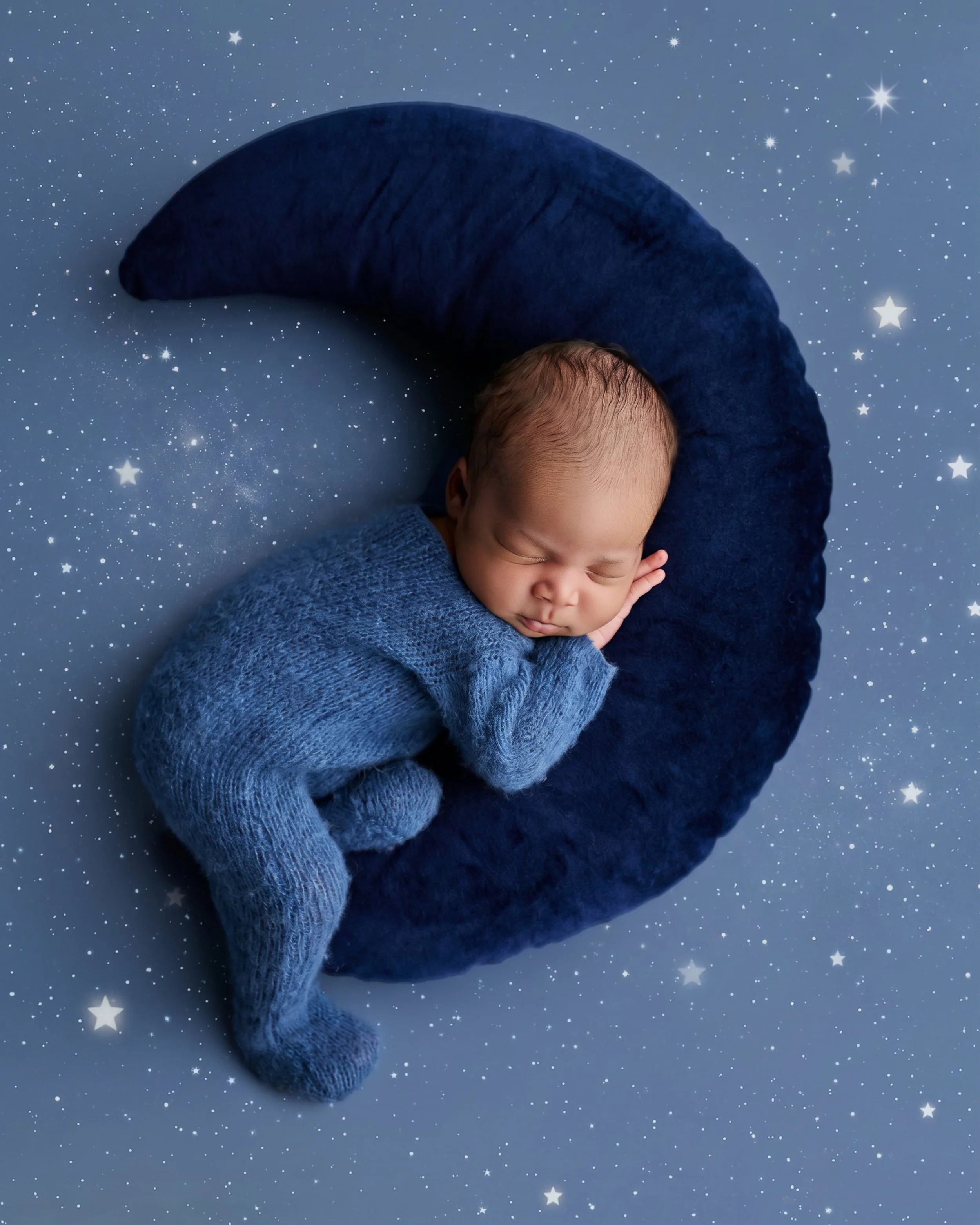 Newborn baby peacefully sleeping on a crescent moon prop during a fine art newborn photography session in Houston, Texas.