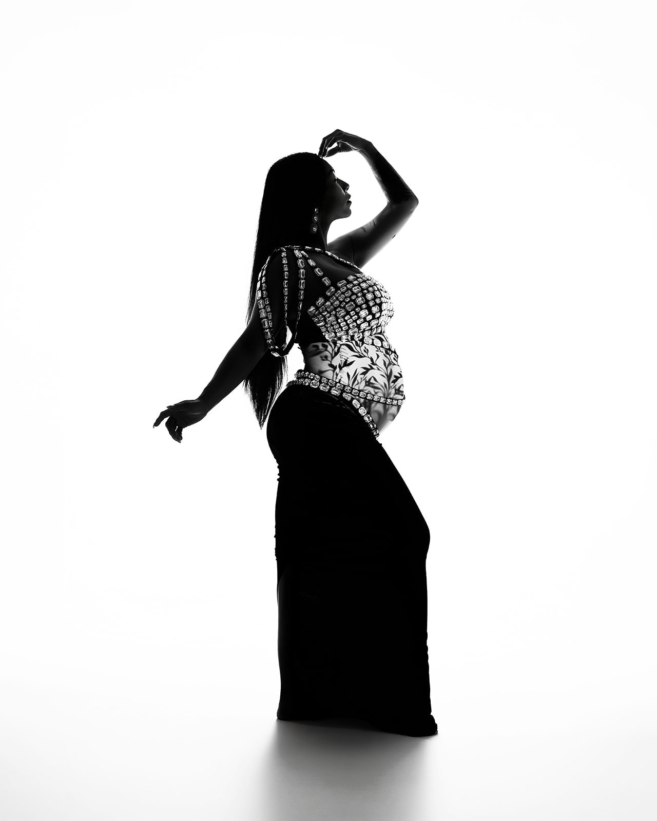 High contrast black and white silhouette of a pregnant woman in an editorial studio maternity portrait in Houston.