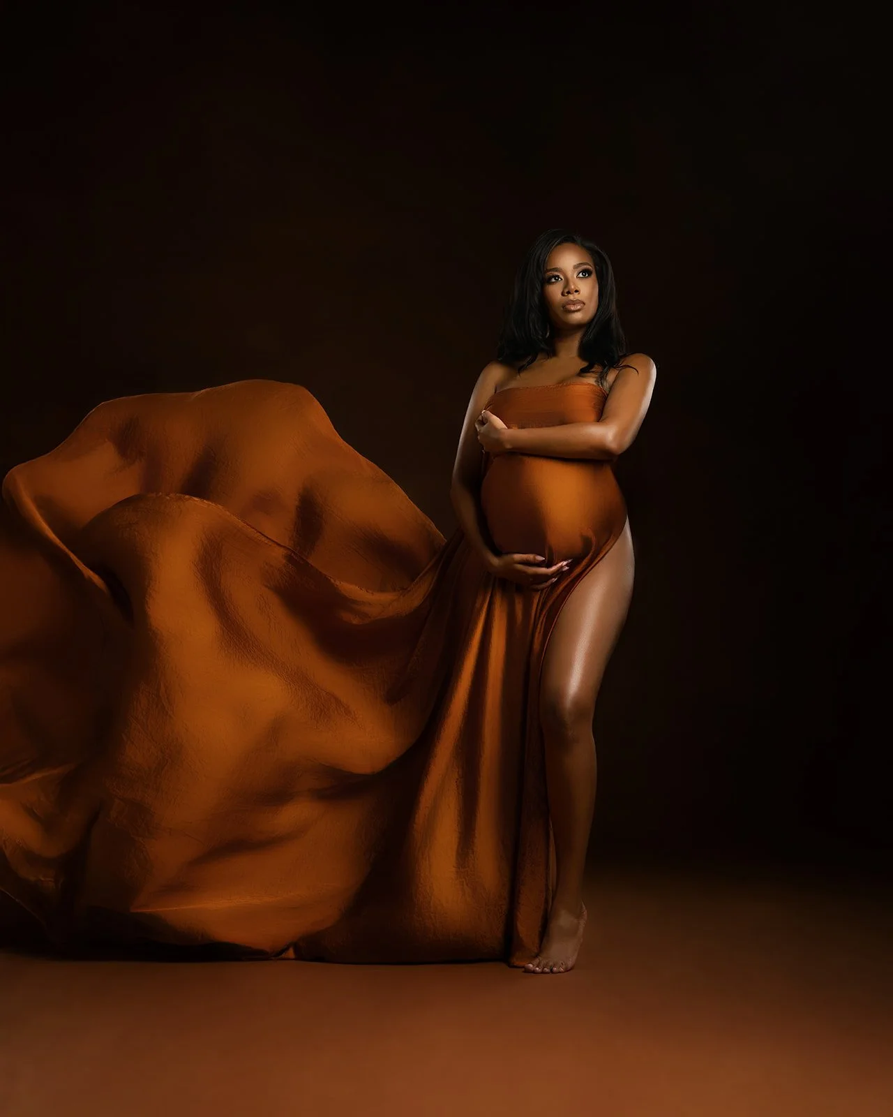 Dramatic maternity portrait photographed with sculpted lighting in studio