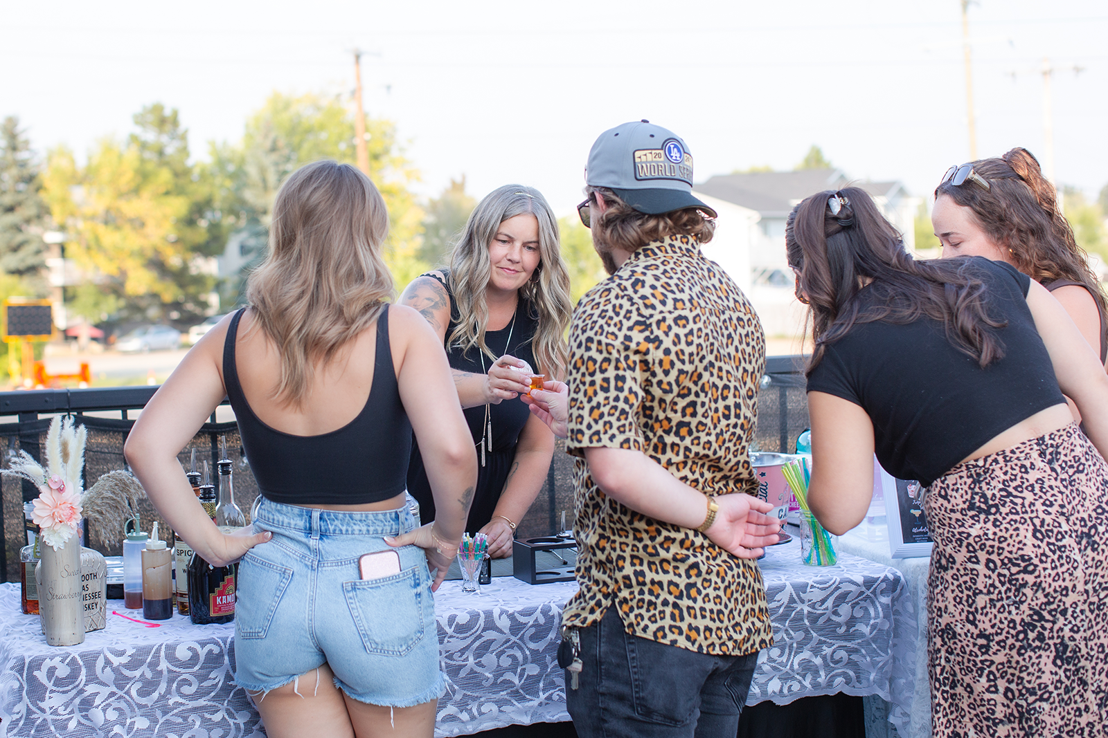 Rosie Silvaggio passing a shotglass to a customer at a summer bartending event