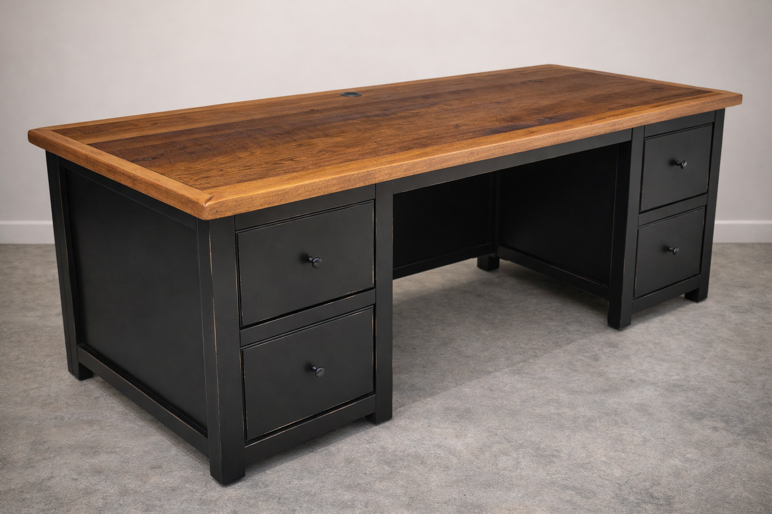 Custom executive desk featuring a solid hardwood top with a black painted base and multiple drawers for storage. Built by hand for home offices and professional workspaces.