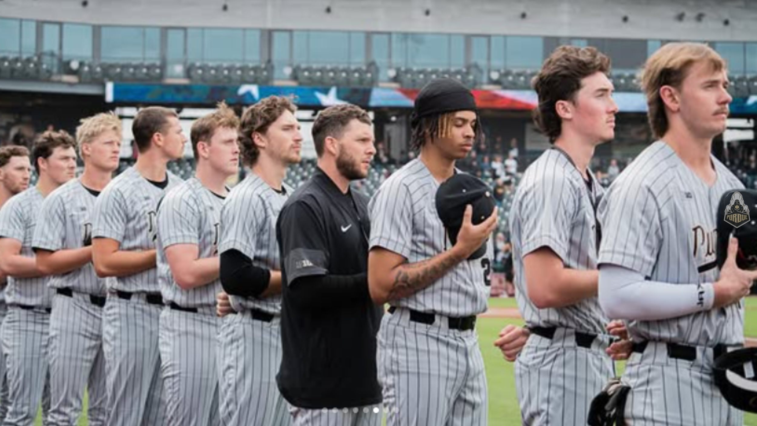 An image of Purdue baseball players with hats off for National Anthem.