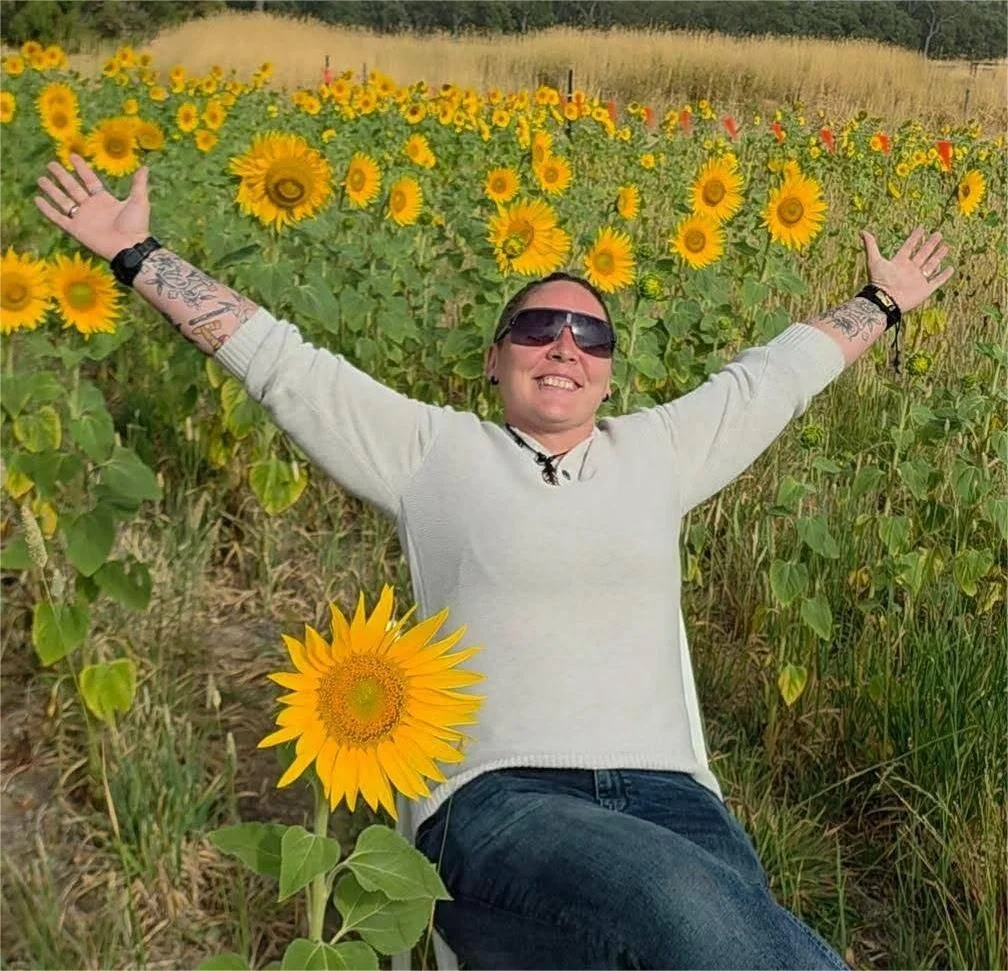 a picture of Nico sitting among some sunflowers