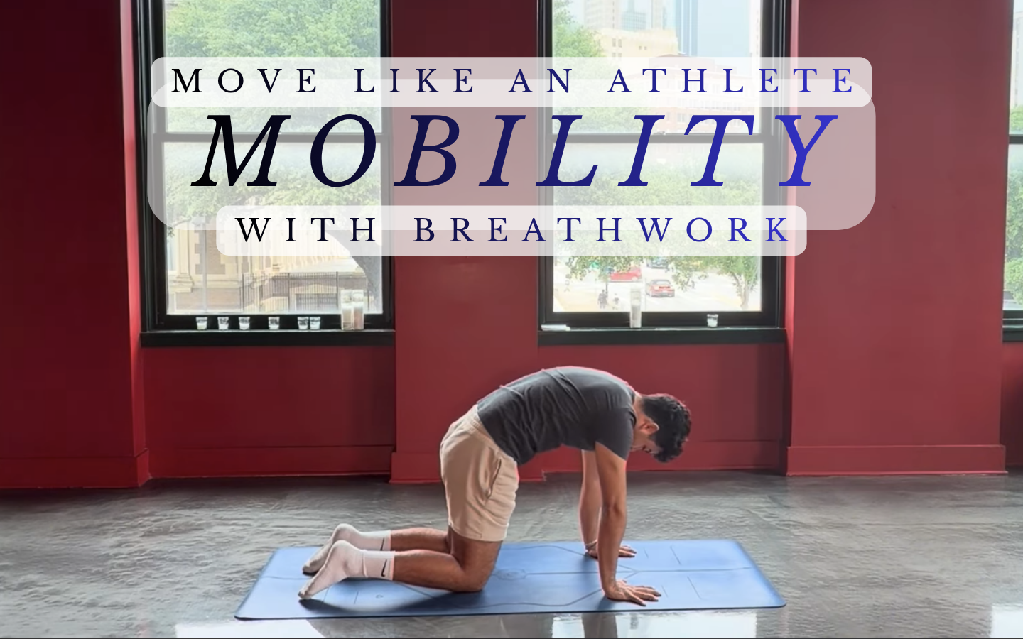 A man practicing a yoga pose on a blue mat indoors with large windows in the background. Overlaid text encourages moving like an athlete with breathwork.