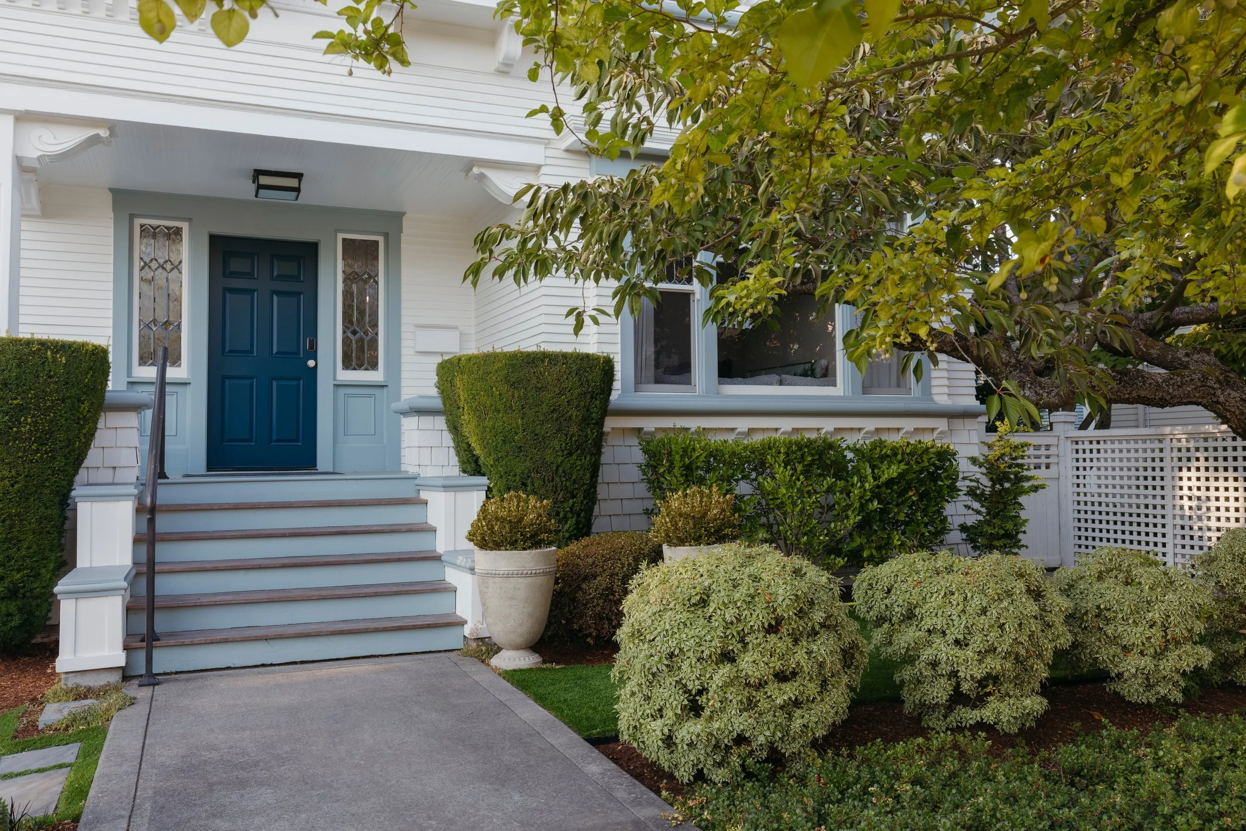 Front steps leading to the deep blue door and leaded glass sidelights
