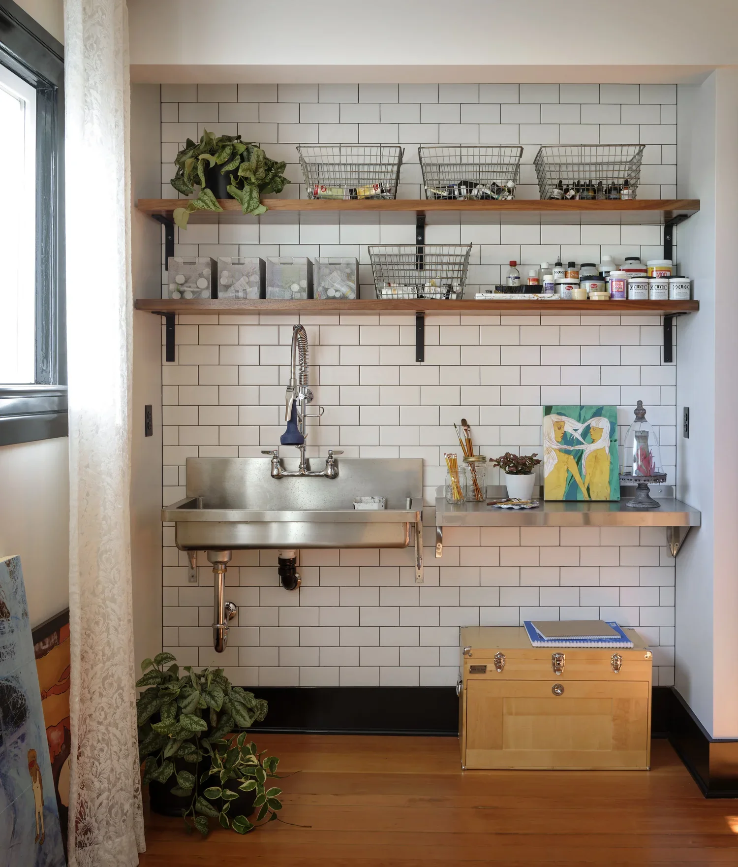 MDID_Seattle-Historic-Landmark_Closet-Conversion-Art-Studio-Industrial-Sink-Hardwood-Floors-Open-Shelves-Storage-Solution-Lace-Drapery-Curtains-Fir-Chest-Potted-Plan.webp