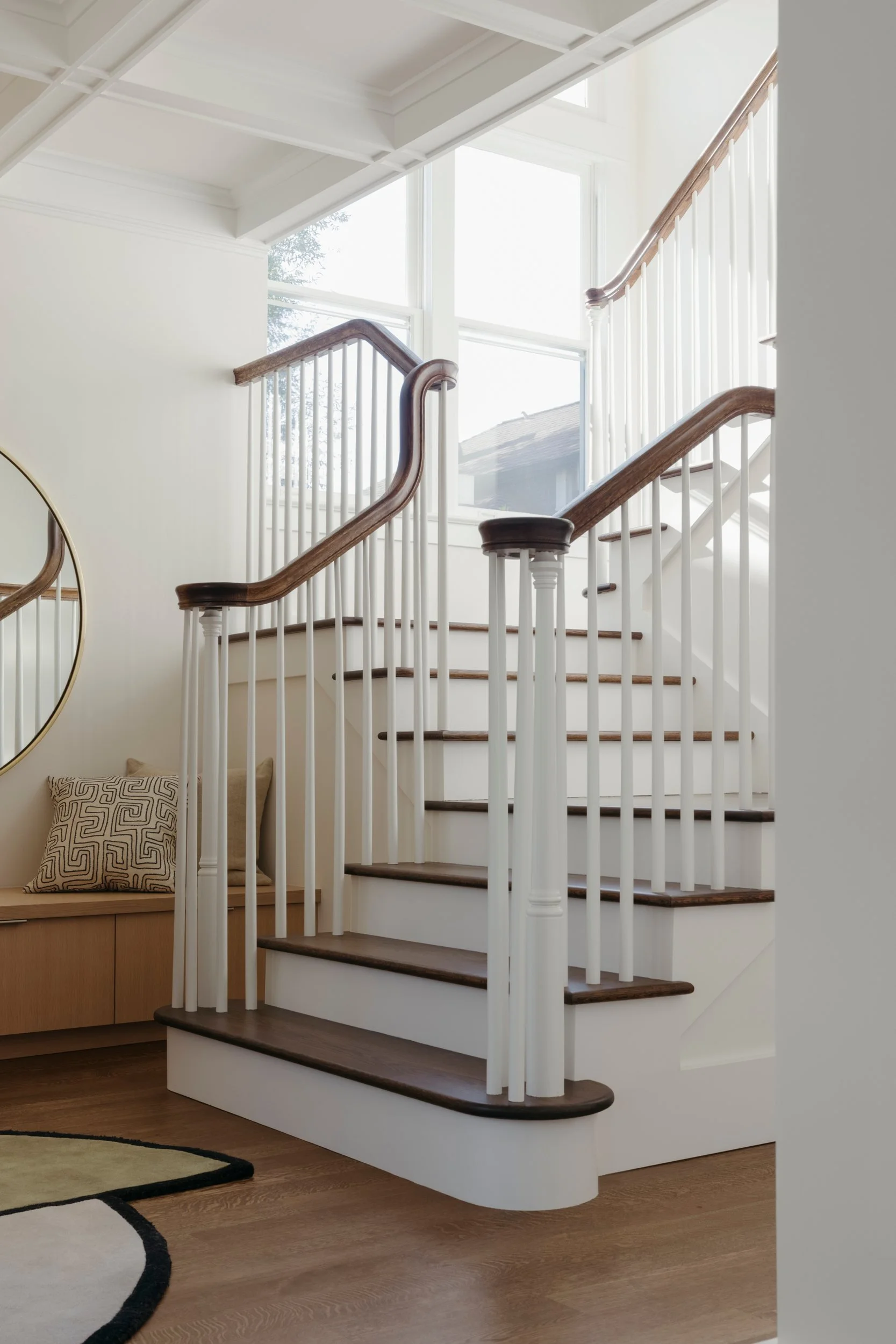 Stair hall with white balusters and a stained wood handrail