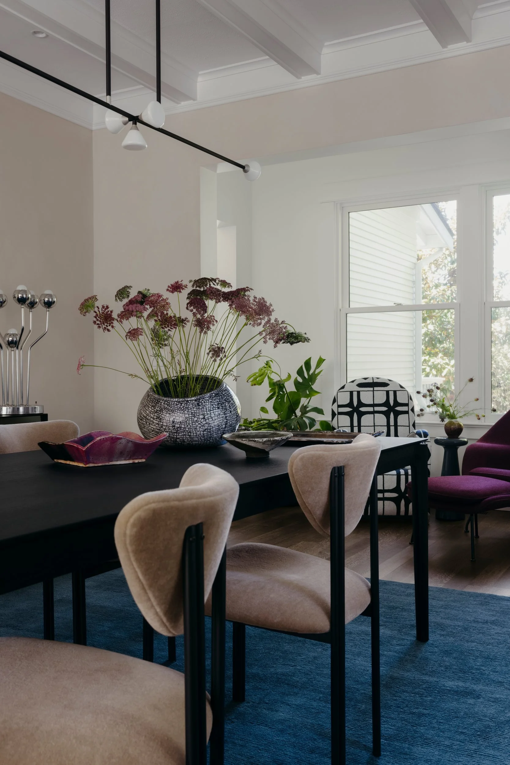 Dining room looking toward the reading room, with beige mohair chairs and a chrome lamp on the buffet