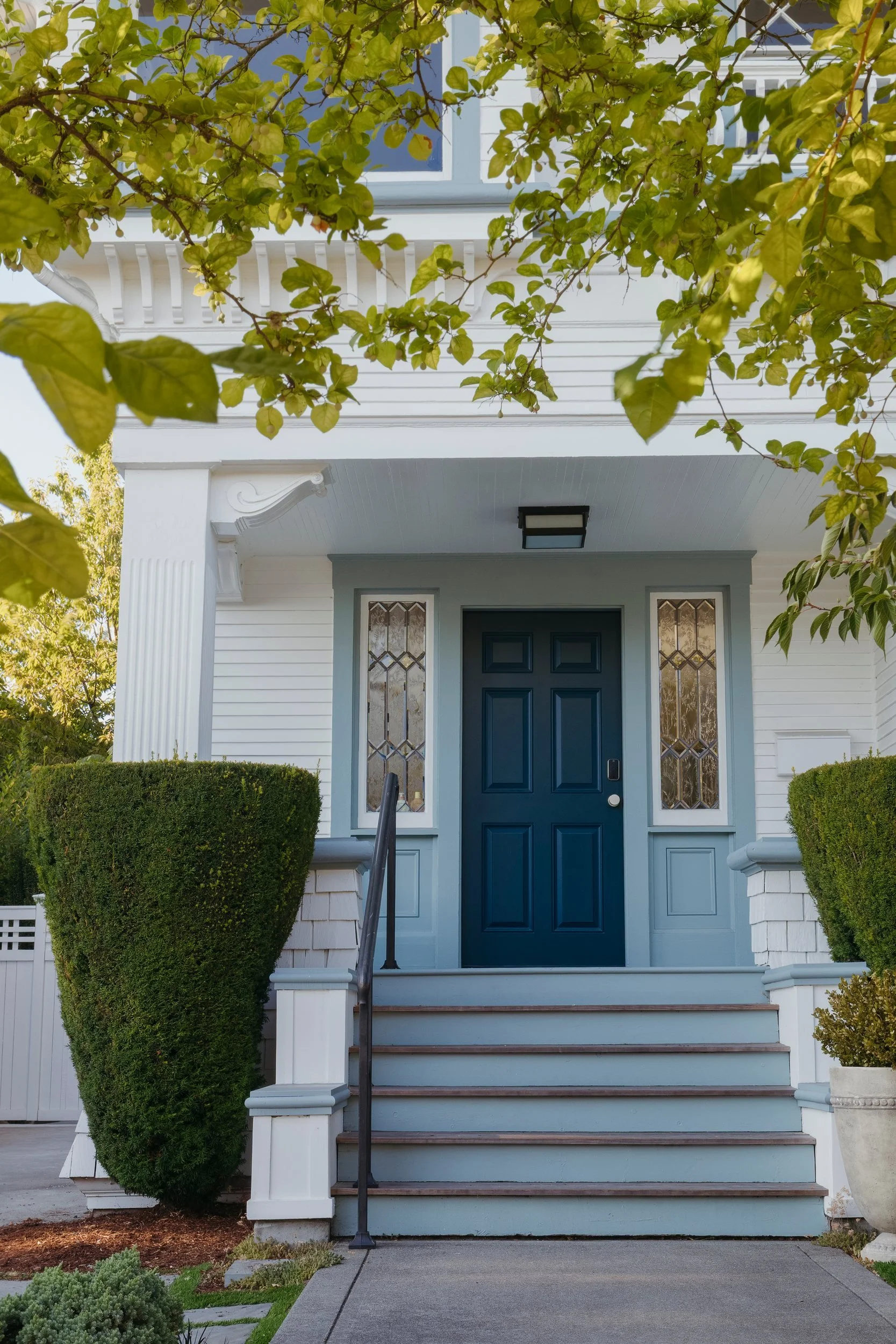 Front door painted deep blue with leaded glass sidelights