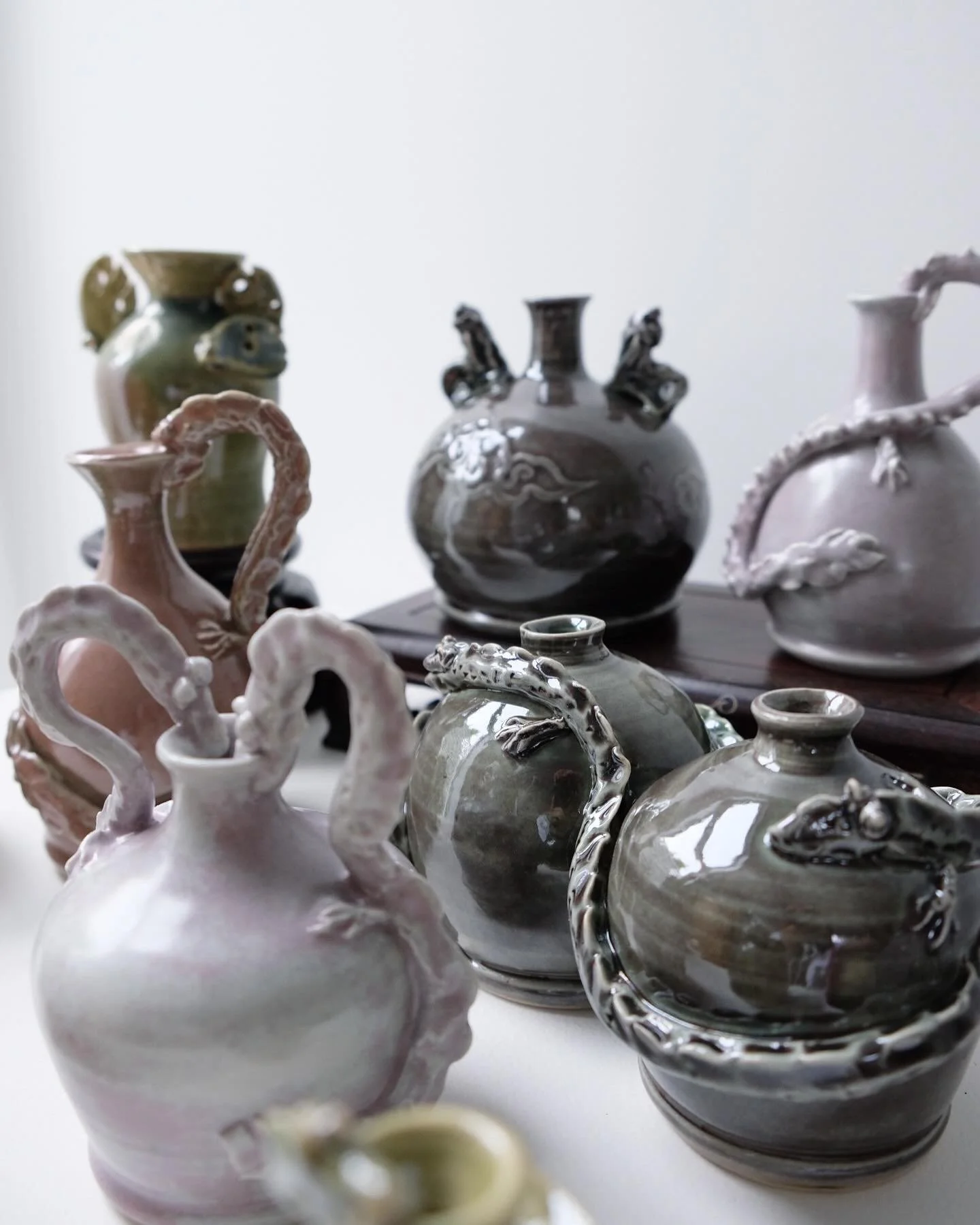 Collection of decorative ceramic vases with dragon motifs displayed on a table.