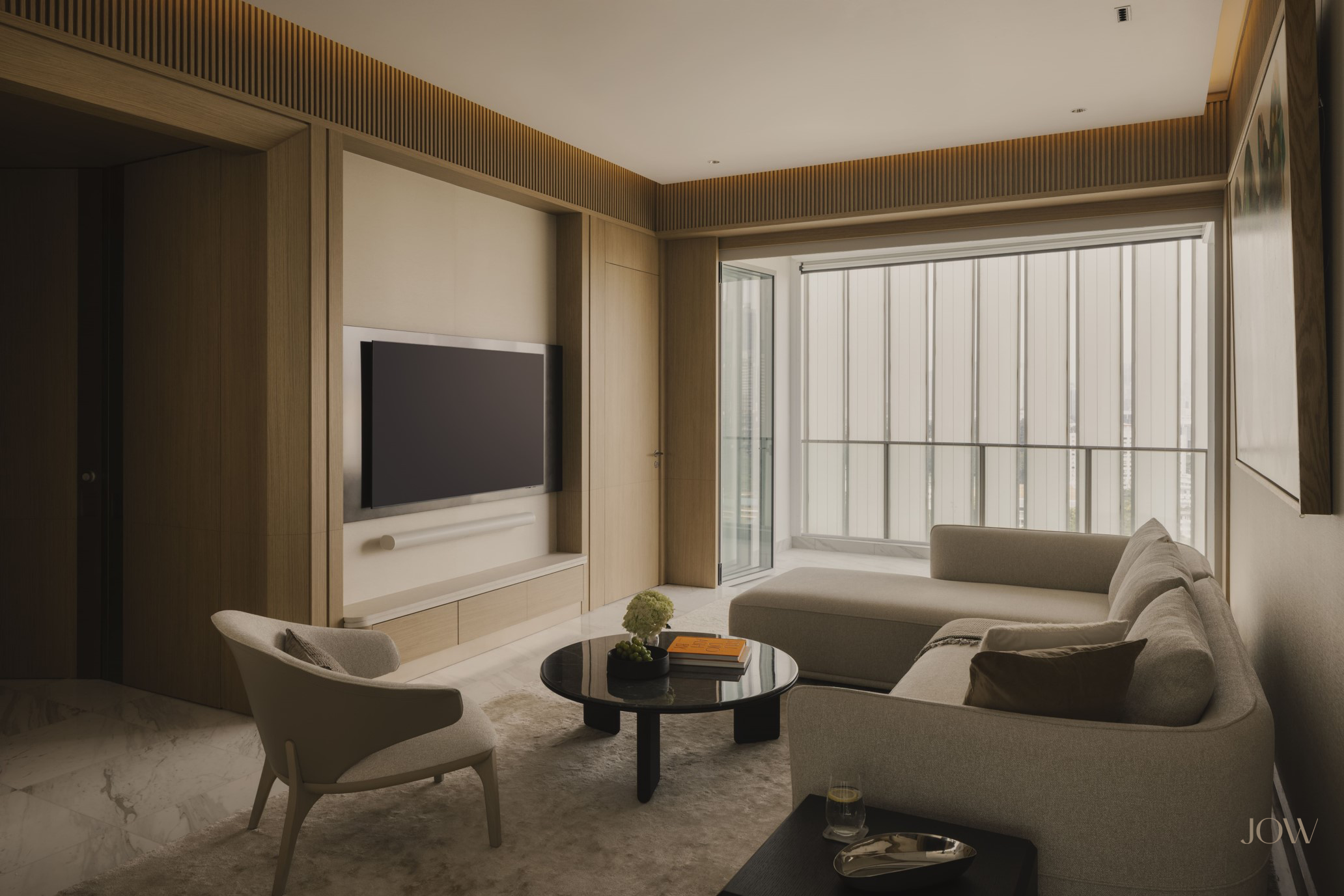Modern living room interior design defined by crafted light oak wall panels and a bespoke wall-mounted TV console with a natural stone top. Expansive windows bring in natural light, accentuating the refined material palette and calm elegance.