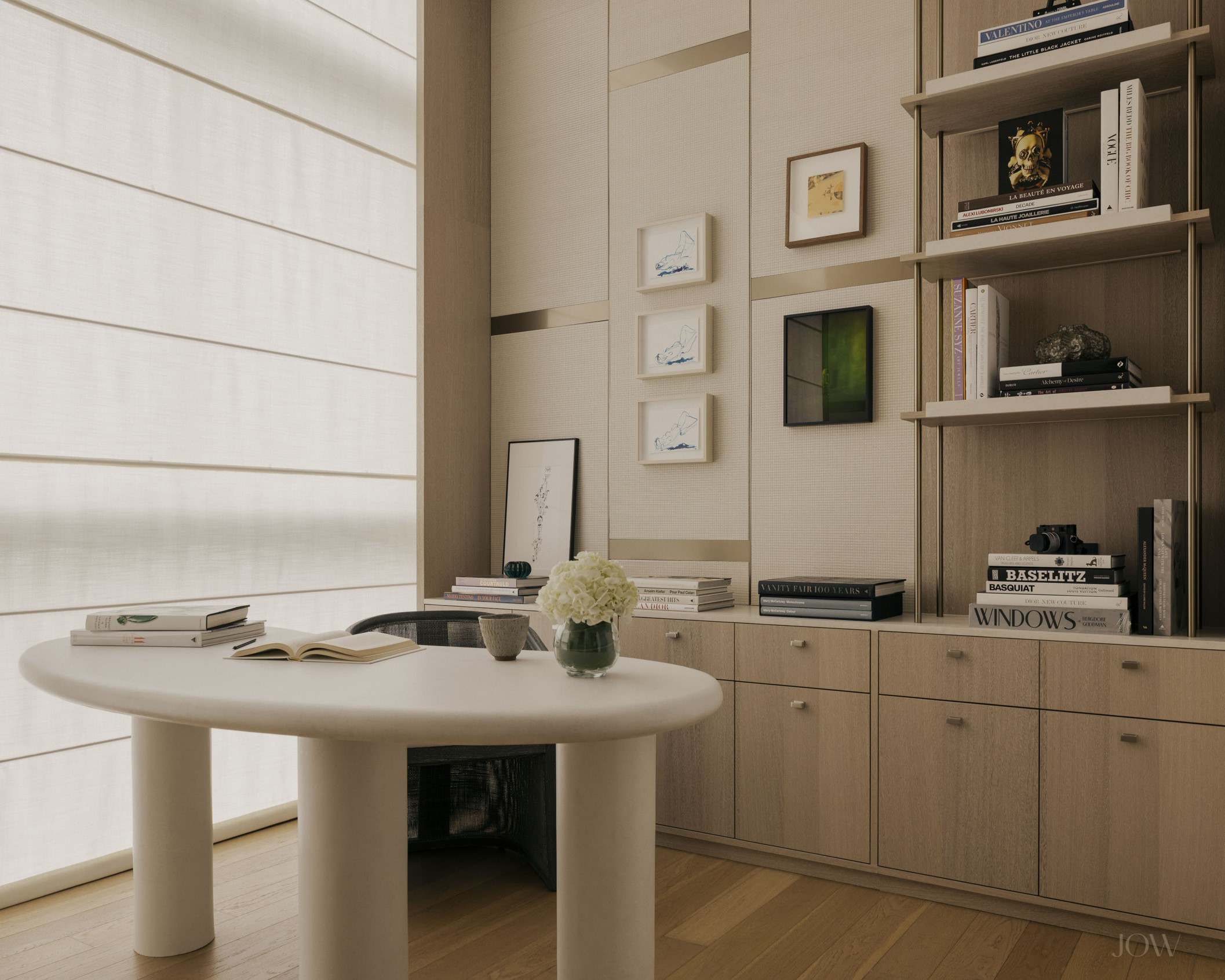 Modern study interior design featuring a custom organic-shaped microcement desk, built-in bookshelves, and ample storage for a refined and functional home workspace.