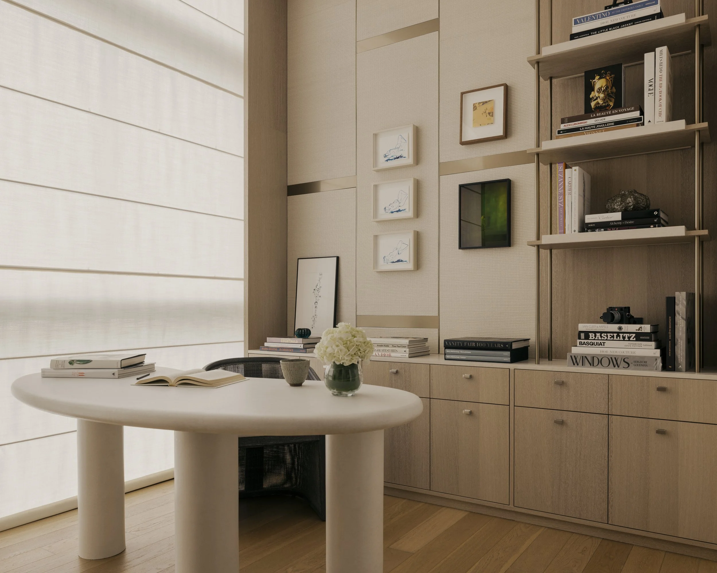 Modern study interior design featuring a custom organic-shaped microcement desk, built-in bookshelves, and ample storage for a refined and functional home workspace.