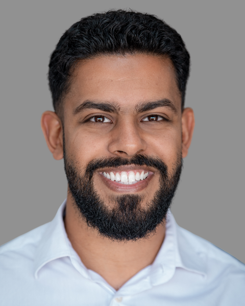Construction company team member with dark hair and a beard wearing a pale blue shirt